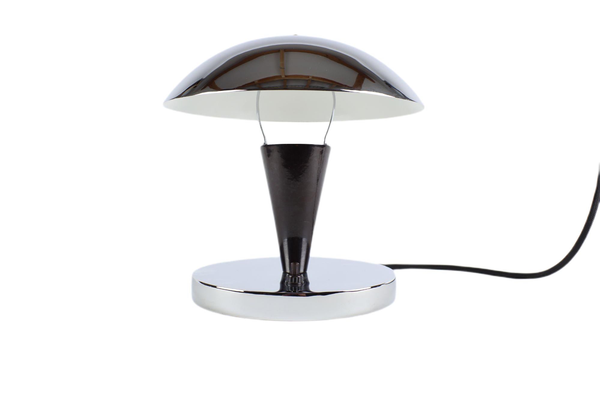 This exclusive functionalist table lamp offers simple shapes and a chrome look. The elegant shape of the mushroom is complemented by a round base. The functional advantage is the tilting luminaire. This little seen and original lamp was made in