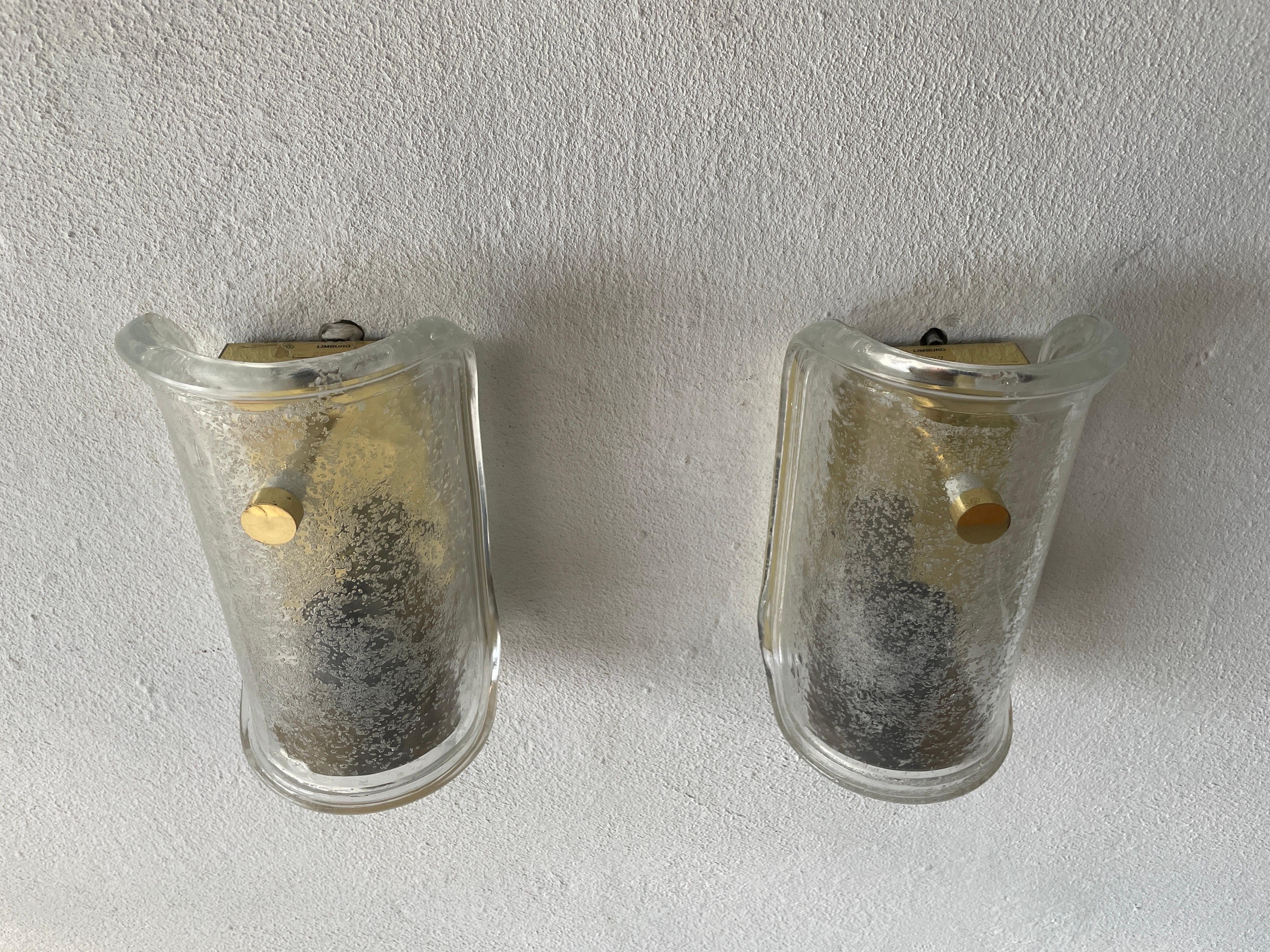 Luxury ice glass and brass pair of sconces by Limburg, 1960s, Germany

Very elegant and Minimalist wall lamps

Lamps are in very good condition.

These lamps works with E27 standard light bulbs. 
Wired and suitable to use in all countries.