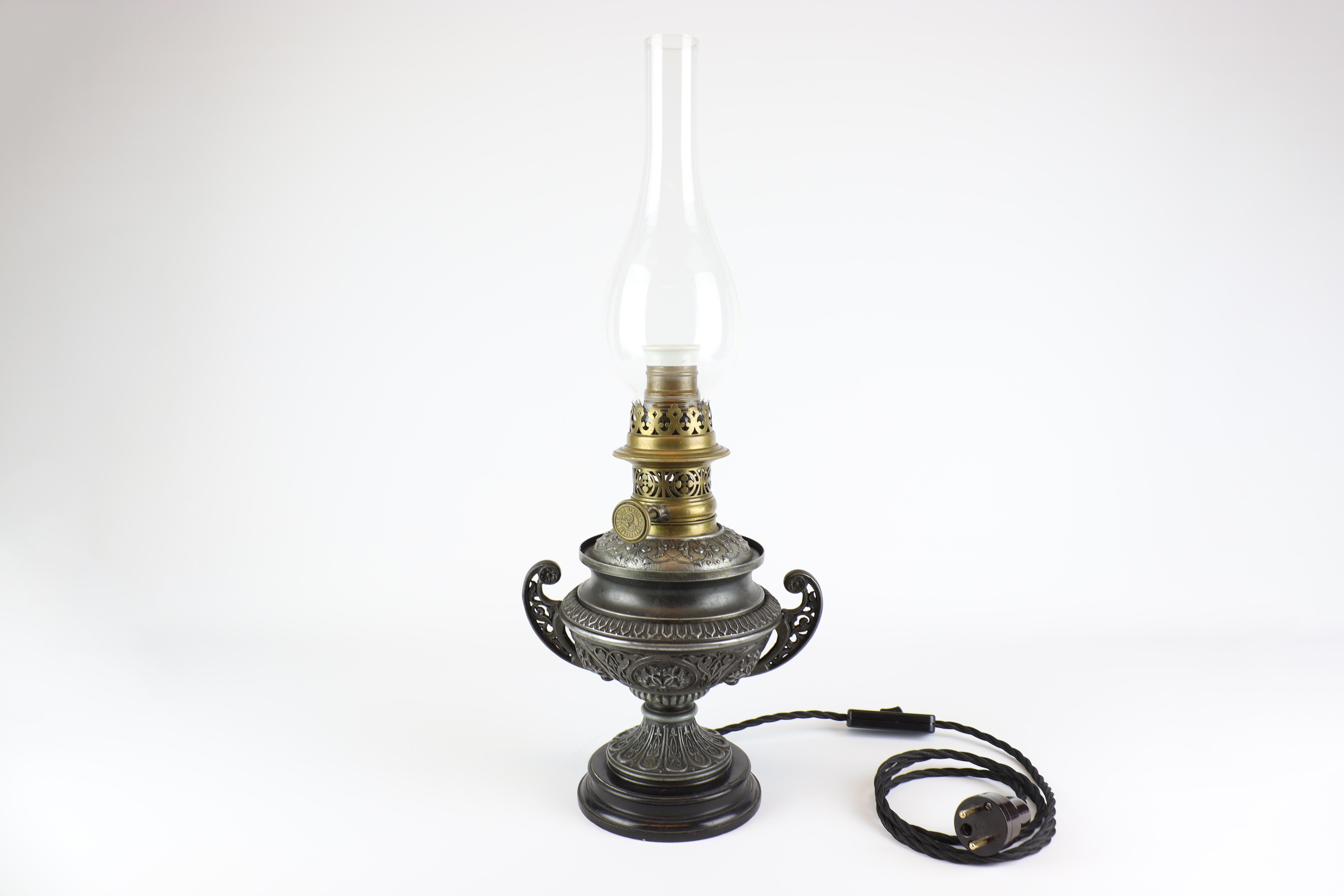 This beautiful processing of a kerosene lamp was created in the workshops of the Viennese company R.DITMAR WIEN, which in its time specialized in the production of kerosene lamps. Specifically, this lamp was made around 1900, it is in its original