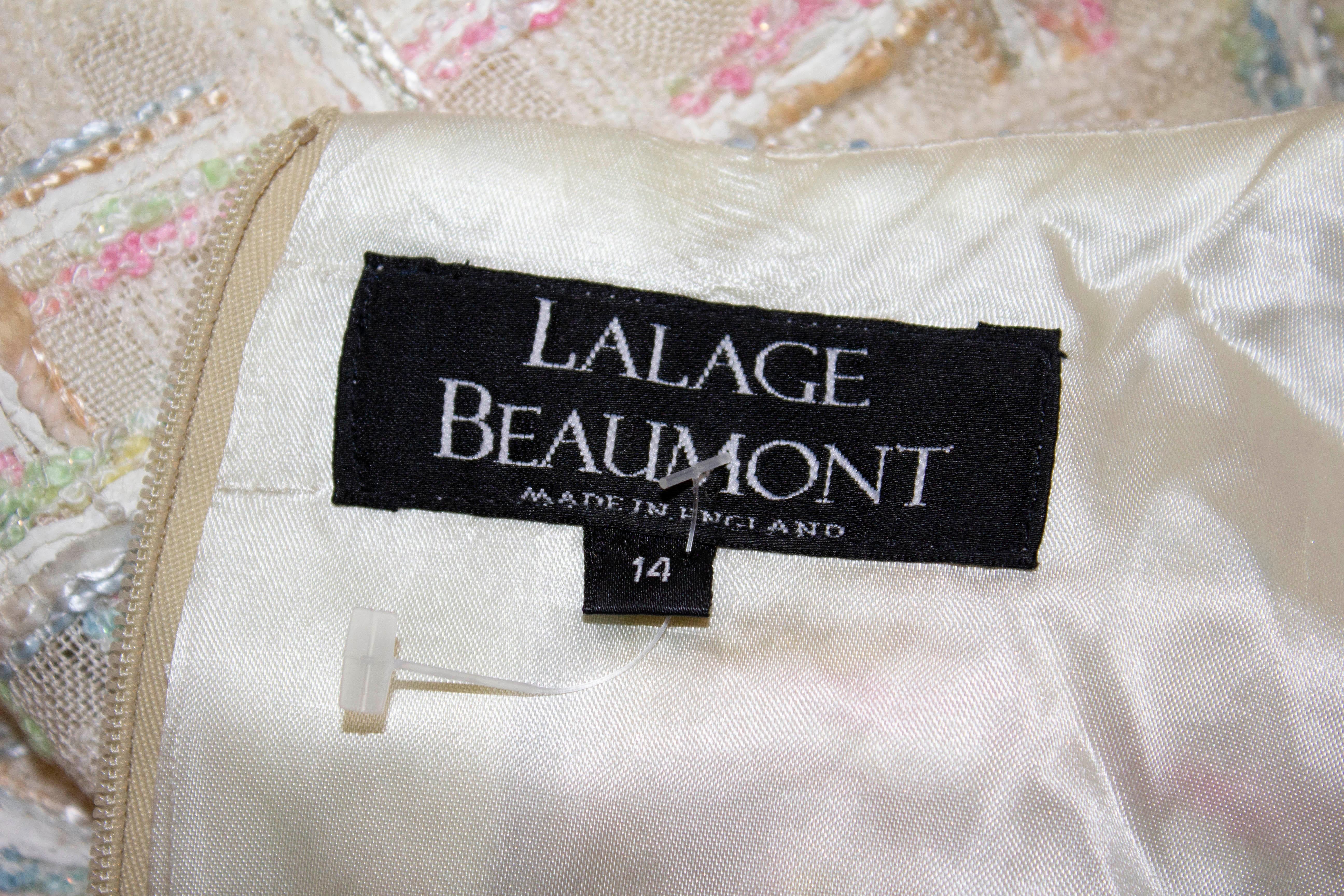 A luxurious and pretty dress for Spring / Summer from Lalage Beaumont . The dress has an ivory background with pink and blue tweed mix. It is fully lined, with elbow length sleaves and a 7 1/2'' slit at the back. Measurements: Bust 36'', waist