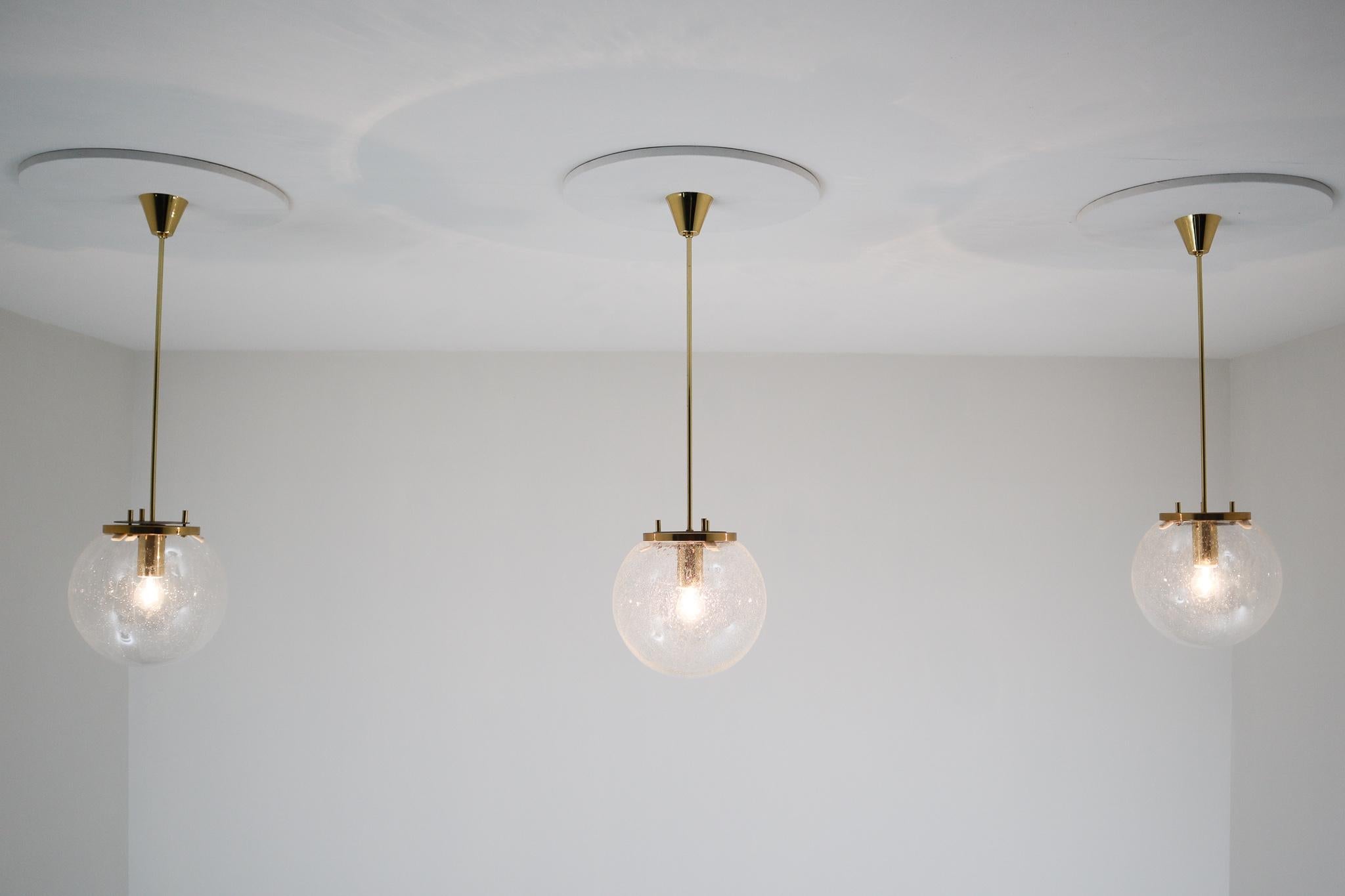 Luxury globe pendants with hand blown glass globe. The brass frame beautifully combines with the hand blown glass. The glass is handmade and has little 