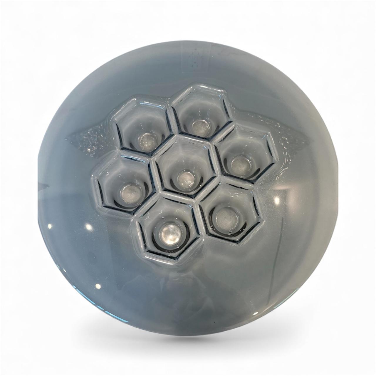 The designer decor bowl label fits the Cells Grafit Platter exactly: PlusObject presses identical cellular geometry into a 13.9 in (490 mm) glass blank, then vapor-deposits hematite-grey titanium that shifts from charcoal to steel blue as guests