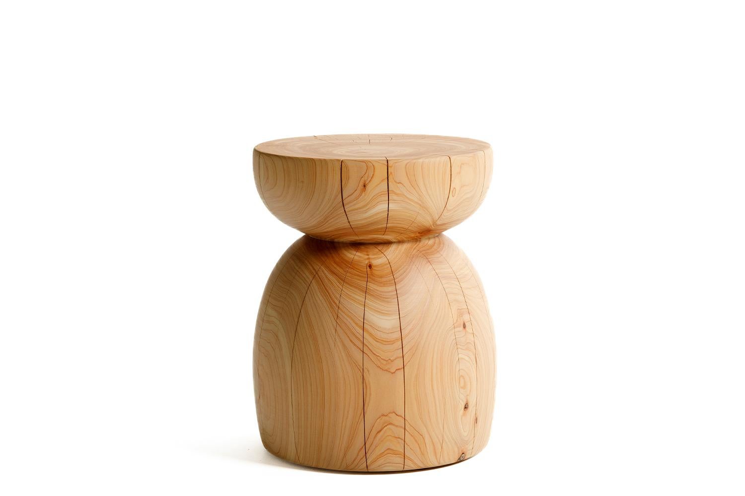The Origin est une table d'appoint organique moderne et sculpturale, fabriquée à partir d'un bloc massif de macrocarpa (cyprès de Monterey). Le bois est fini avec un frottement à la main, à faible V.I.C., avec des huiles végétales naturelles pour