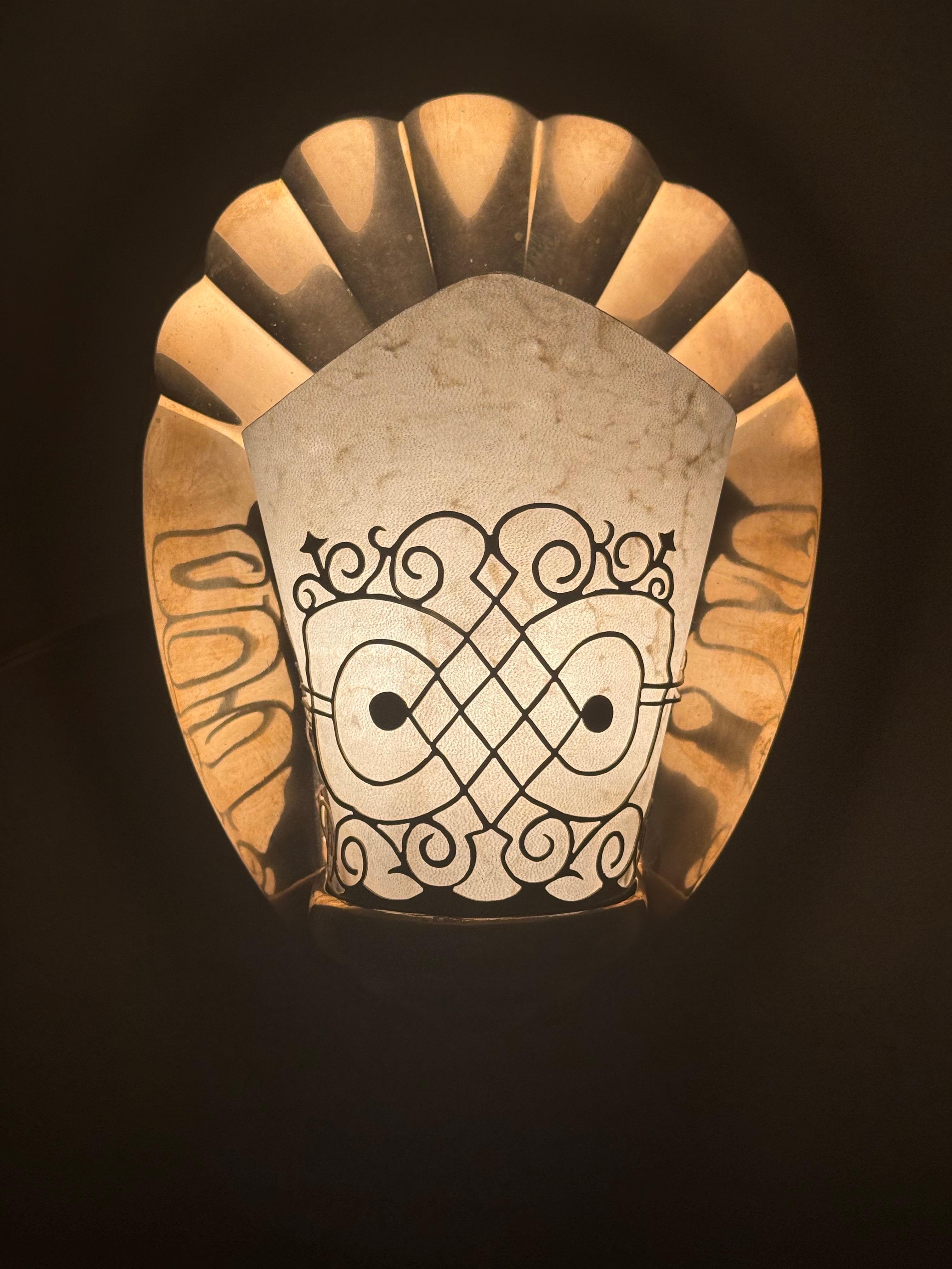 Cette paire de lampes de luxe des années 1920-1930 est vraiment unique en son genre. La plaque arrière a été amoureusement moulée en forme de coquillage, et le bronze doré a été poli à la main pour refléter la lumière dans un ton d'or chaud. La