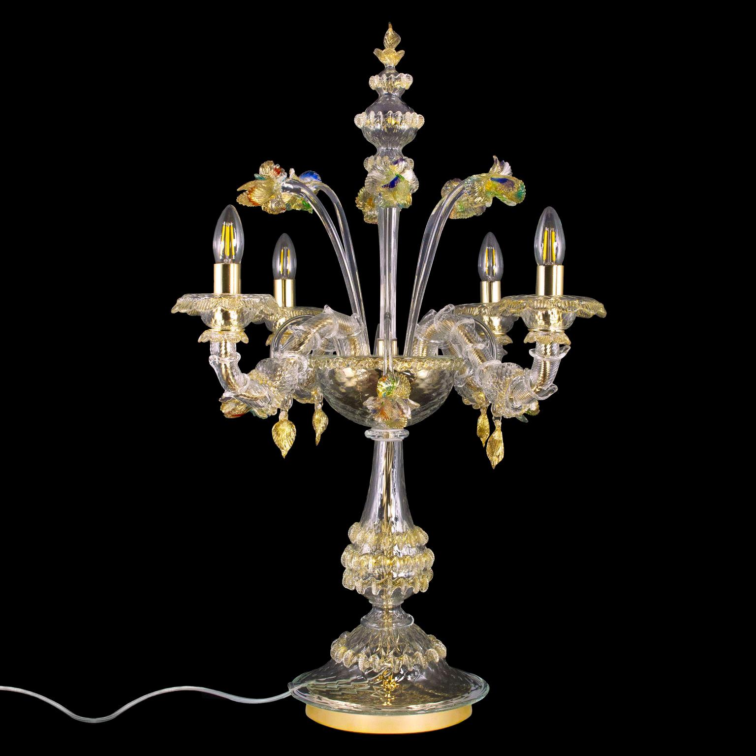 Luxury Rezzonico flambeau lamp 4 arms, clear and gold Murano glass by Multiforme.
The flambeau lamp is a really elegant and luxury table lamp enriched with flowers. The lights are upwards. 
Suitable to enlighten every space and creating a magic