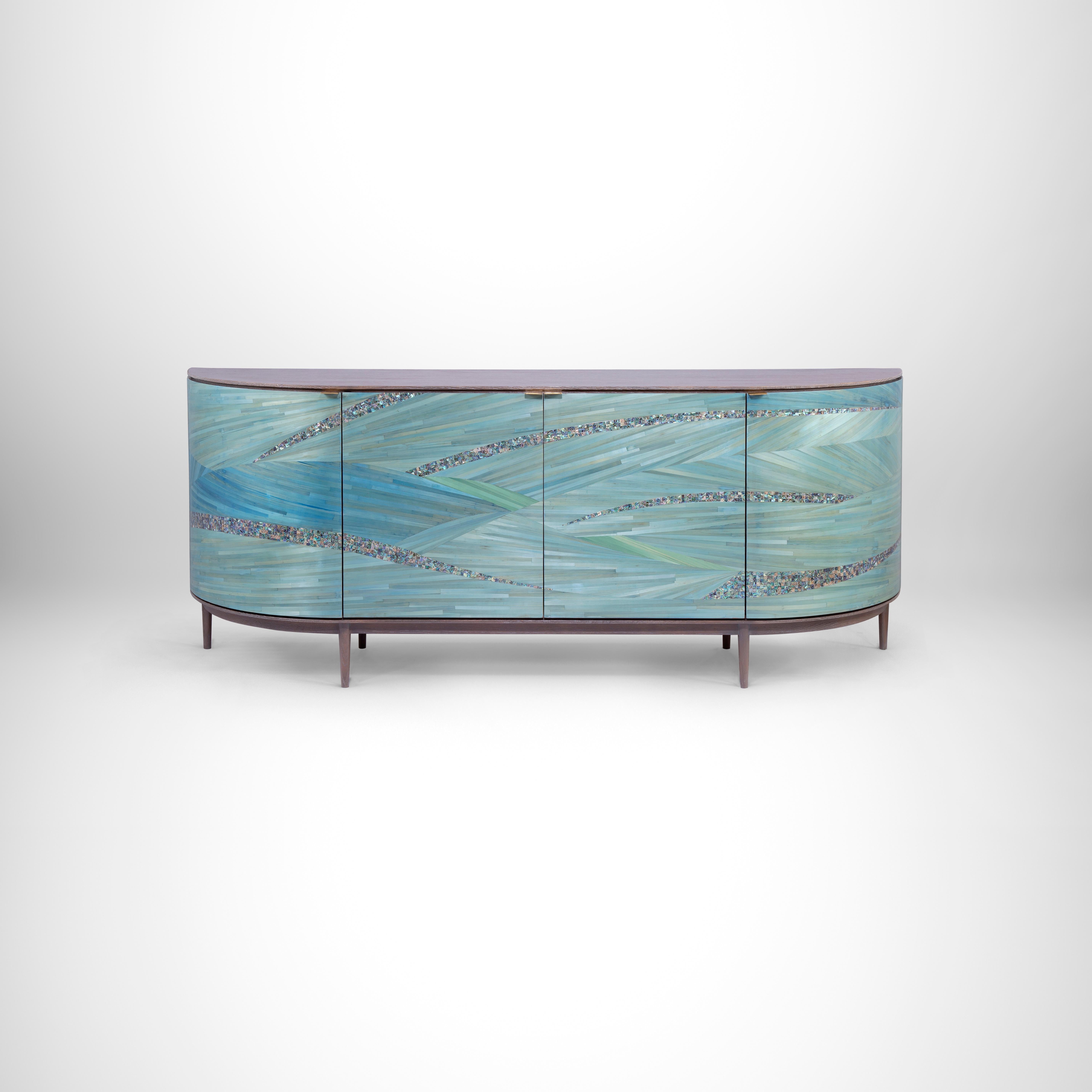 Luxury sideboard with Rare Turquoise Mother of Pearl and Hand-Laid Blue Straw.
A distinctive dinning buffet that is a feast for the eyes. Hand-laid luscious shades of blue signature Shewekar-Straw infused with unique turquoise mother of pearl gives