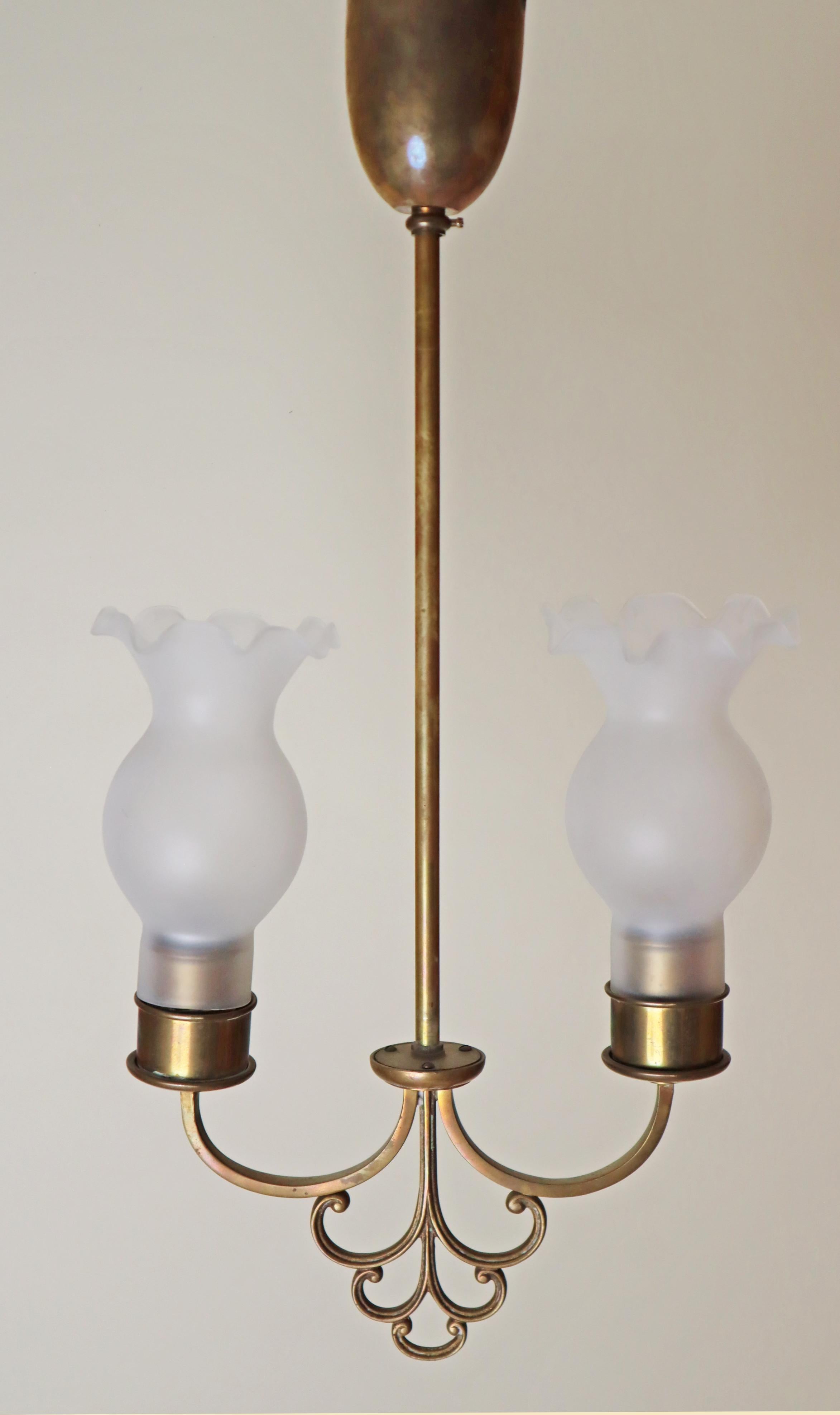 Questa bellissima e semplice lampada a sospensione è stata realizzata negli anni '20 ed è un pezzo davvero unico. Il suo design è semplice e lineare e la lavorazione è magistrale. Il baldacchino è realizzato in ottone massiccio e presenta