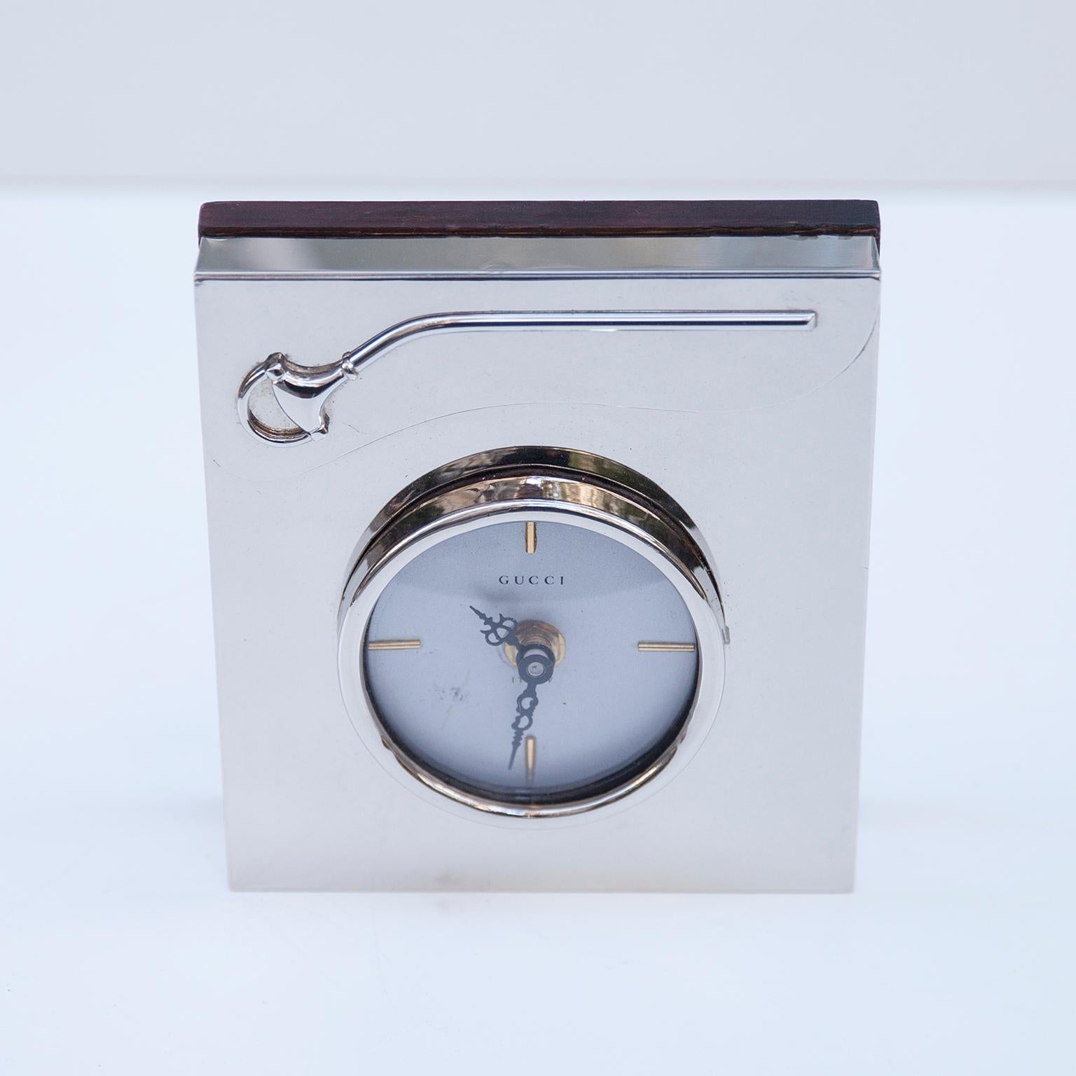 Elegant vintage Gucci table clock made in chrome and wood, marked with Gucci and the Gucci famous stirrup holder.
 
 