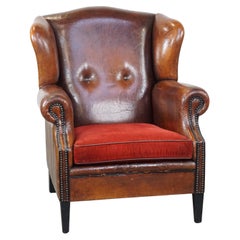 Luxury vintage, stylish sheepskin armchair with a red corduroy seat cushion