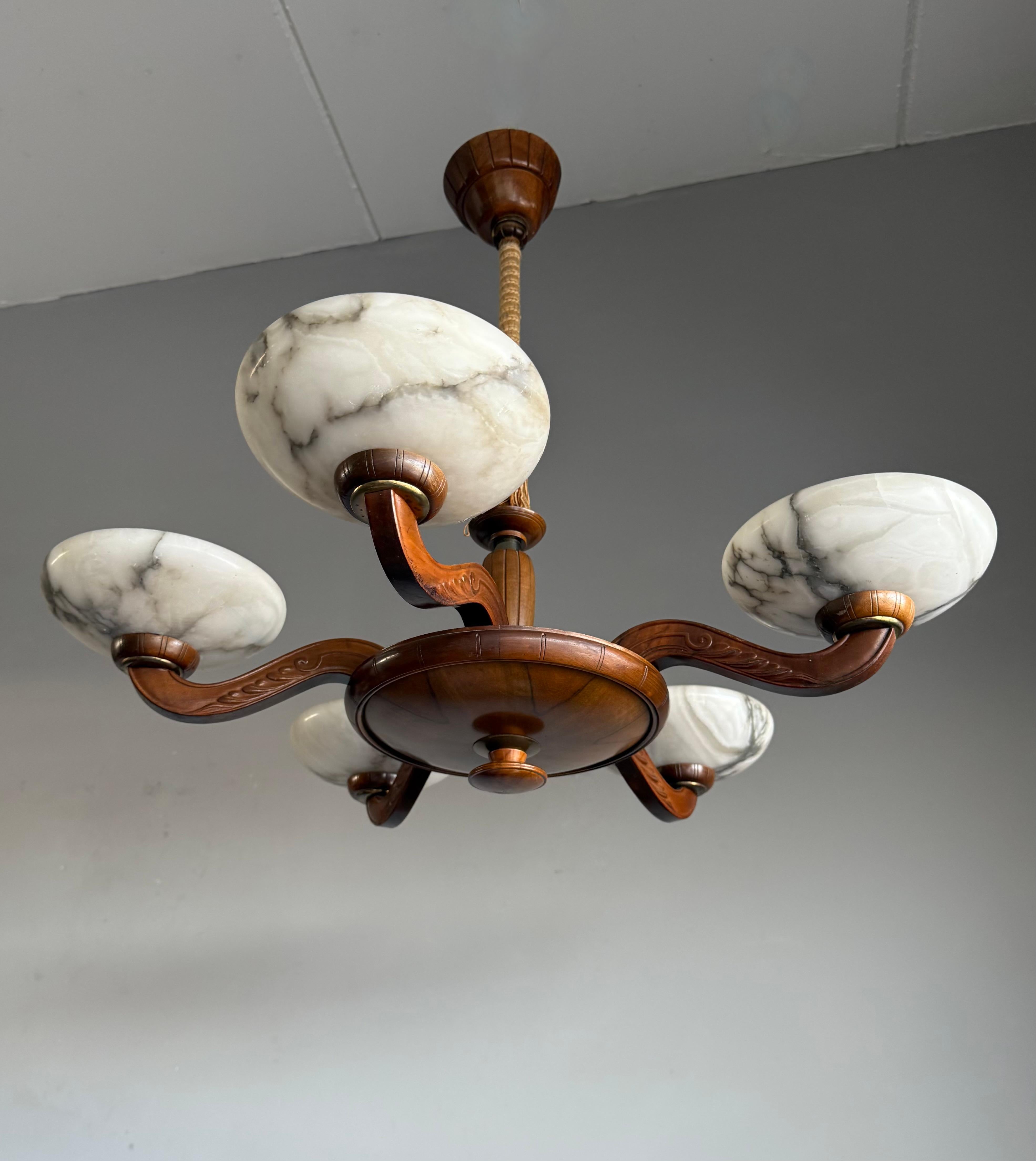 Striking and exclusive 1920s solid wooden and alabaster light fixture for the perfect atmosphere.

If you are looking for a remarkable light fixture to grace your living space then this antique Art Deco chandelier from the earliest years of the 20th
