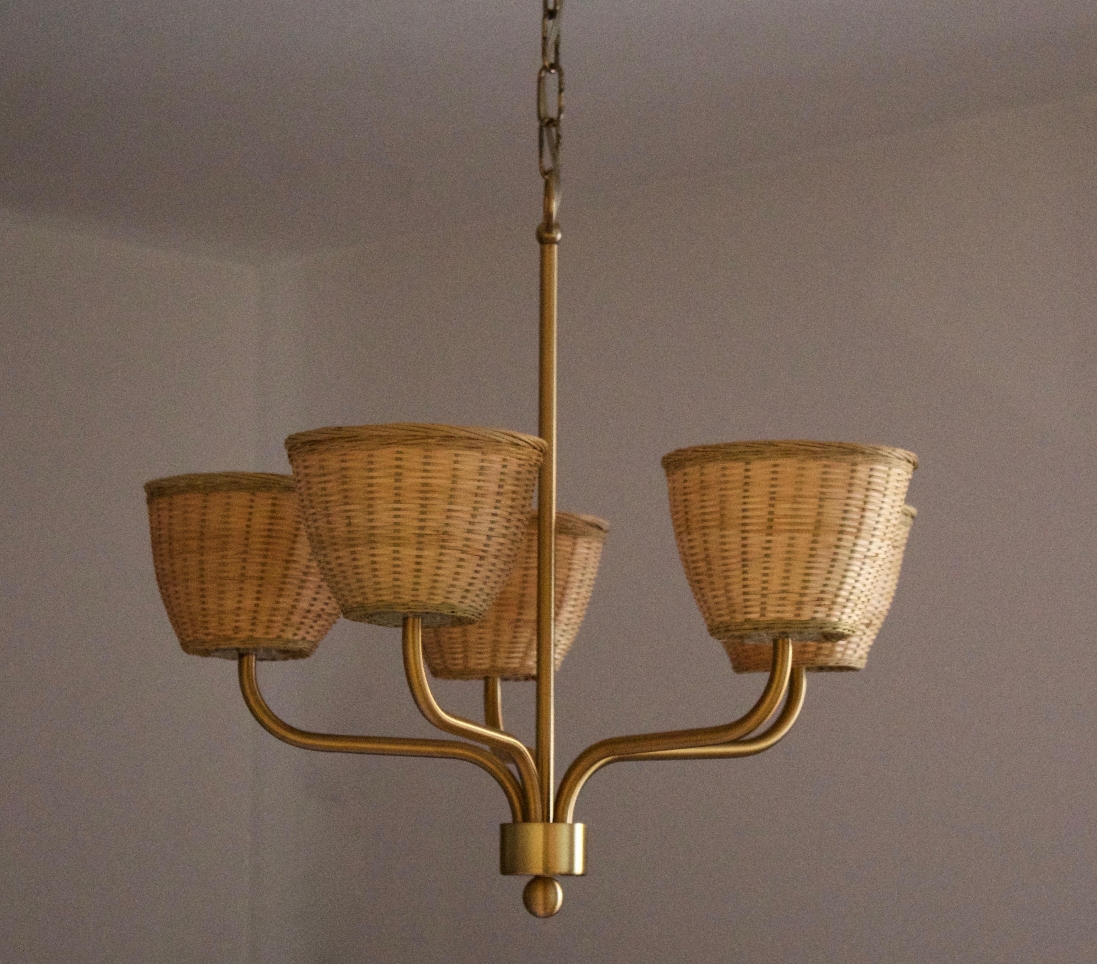 A chandelier light. By Luxus, Sweden, 1970s. In brass. Assorted vintage rattan lampshades.

Five-armed and features transparent plastic sockets. Stated height includes full drop.

Other designers of the period include Axel Einar Hjorth, Roland