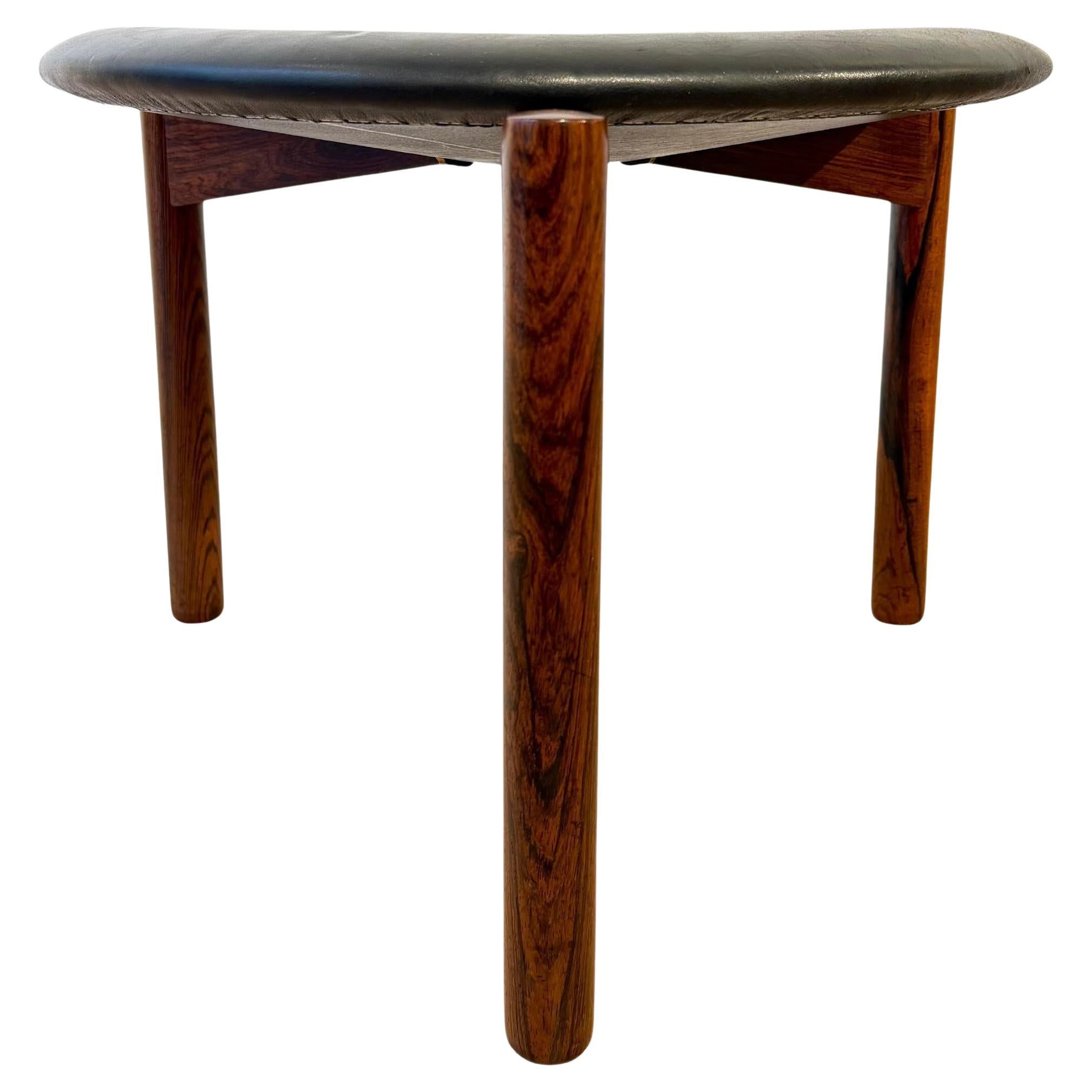 Un tabouret au design très raffin�é en bois de rose et cuir signé par les frères Kristiansson pour leur maison d'édition Luxus. C'est un très bel objet de décoration et en même temps un siège supplémentaire ou une élégante table d'appoint. Le