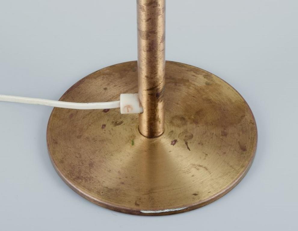 Swedish Luxus, Sweden. Large table lamp in brass with shade in plastic and brown fabric. For Sale