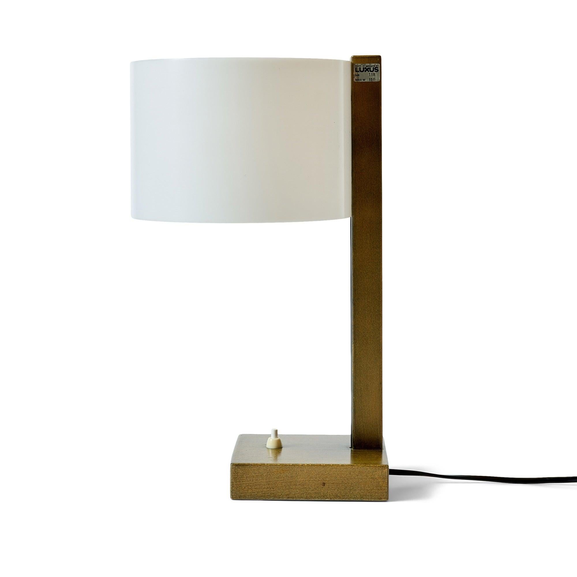 Une élégante lampe de table géométrique encadrée de bois avec un abat-jour en acrylique filé.