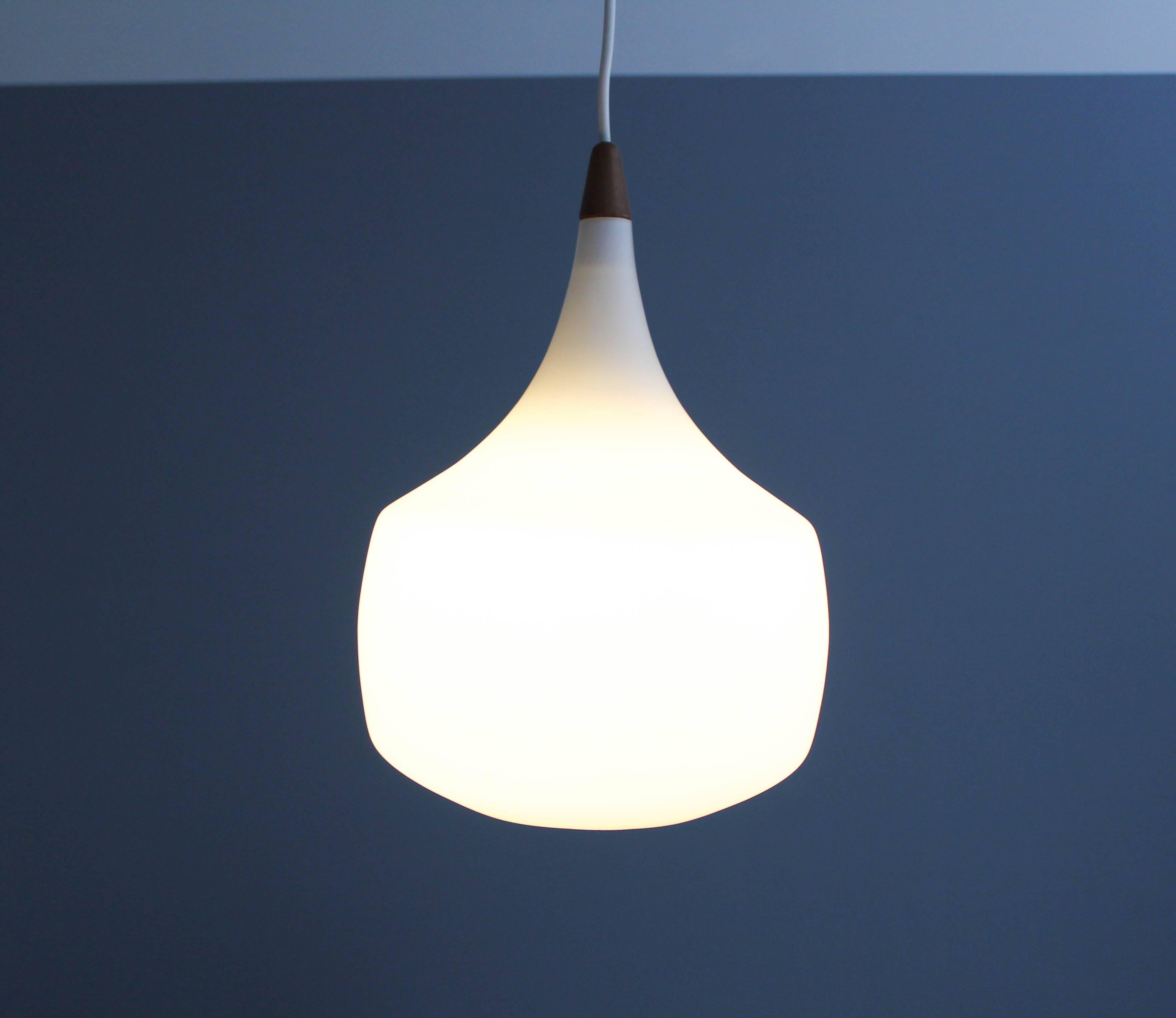 Mid-century opaline glass and pendant lamp by Swedish manufacturer Luxus, designed by Uno and Östen Kristiansson. Luxus was a Vittsjö based Swedish manufacturer especially known for their high quality lamps. 

This lamp is in very good vintage