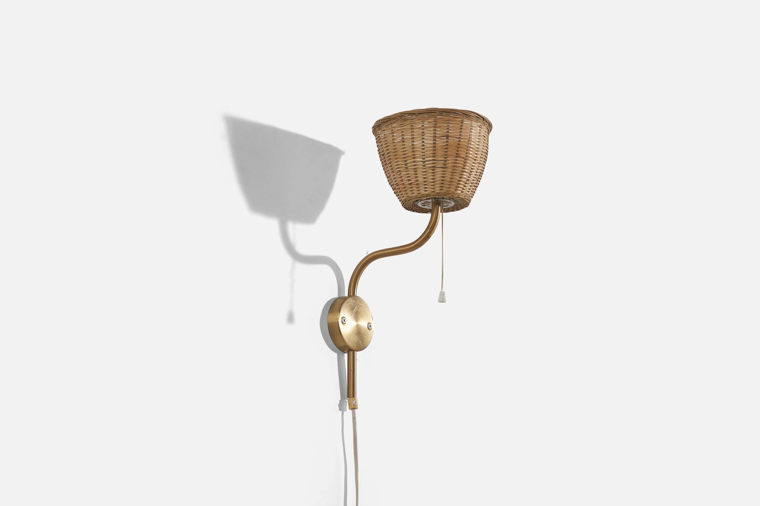 A brass and rattan wall light designed and produced by Luxus Vittsjö, Sweden, 1970s. 

Sold with Lampshade. 
Stated dimensions refer to the Sconce with the Shade. 
Dimensions of back plate (inches) : 3.18 x 3.18 x 0.81 (H x W x D).