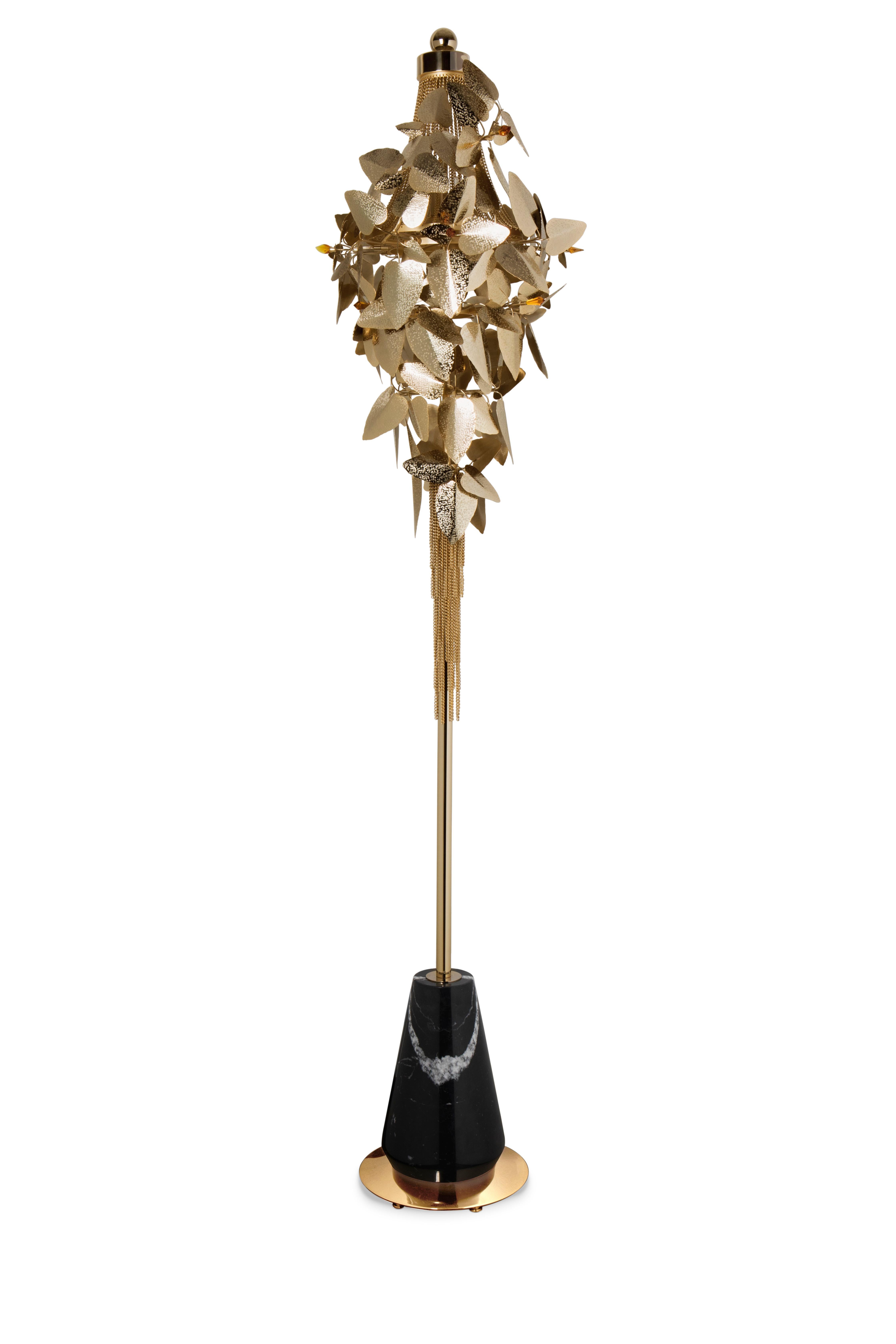 Maintaining the elegant and feminine vibe of the entire family, this McQueen floor lamp will certainly brighten everything around it. The perfect and complex combination of gold plated hammered leaves with amber Swarovski crystals encompasses a