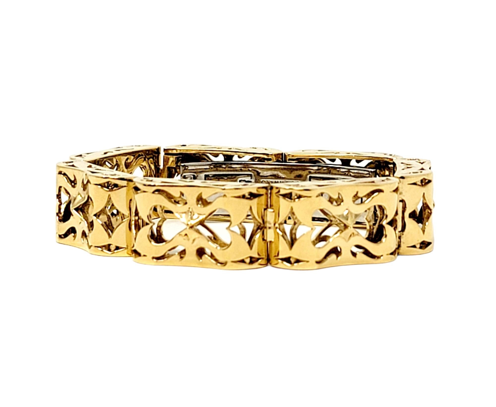 Stunning custom Love bracelet designed by Luz by Houman. Bold and beautiful, this high end designer piece makes a striking statement on the wrist. It features a single row of chunky, wide 18 karat yellow gold links with unique scroll work, as well