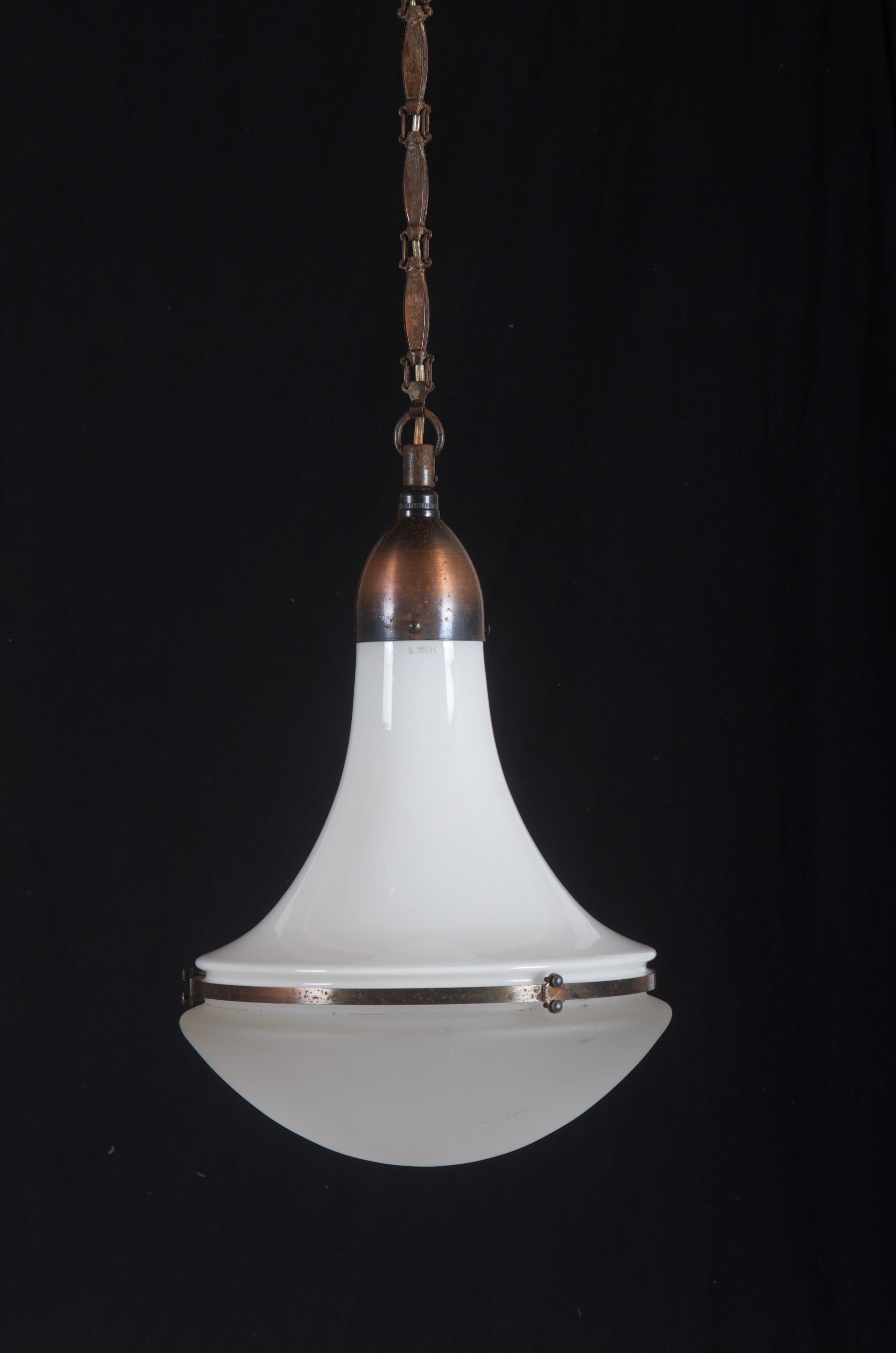 The pendant was designed by Peter Behrens in 1908 for Siemens.
This lamp is completely original with a nice combination of an opaline glass upper shade and a frosted clear glass lower shade.
All metal/copper parts are complete and original. Some