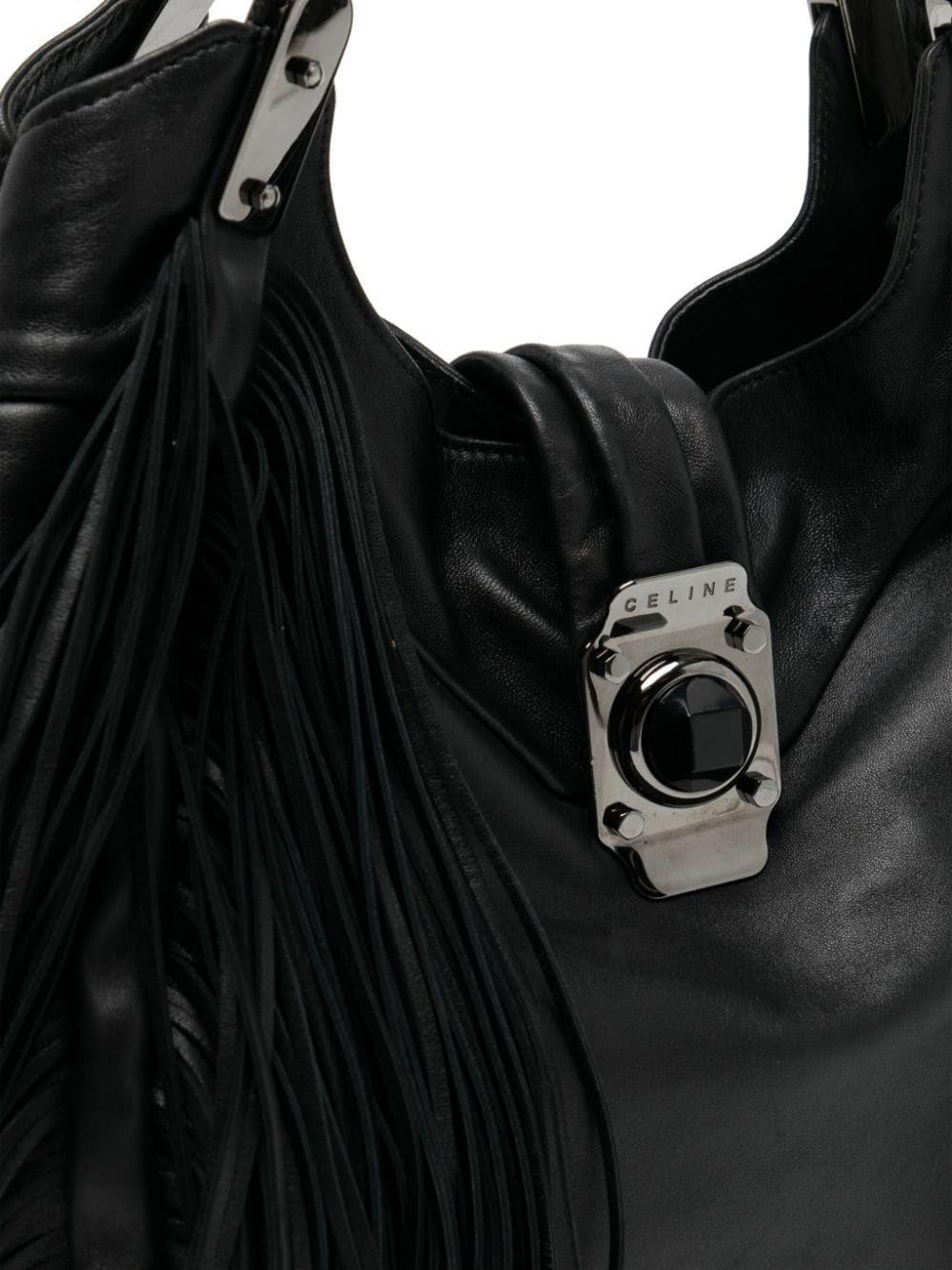 This 100% leather Celine Dimitri Fringed Shoulder bag in dark brown offers a sleek and sophisticated look. With its fringed detailing, it adds a stylish touch to any outfit. The durable leather material ensures long-lasting quality, making it a