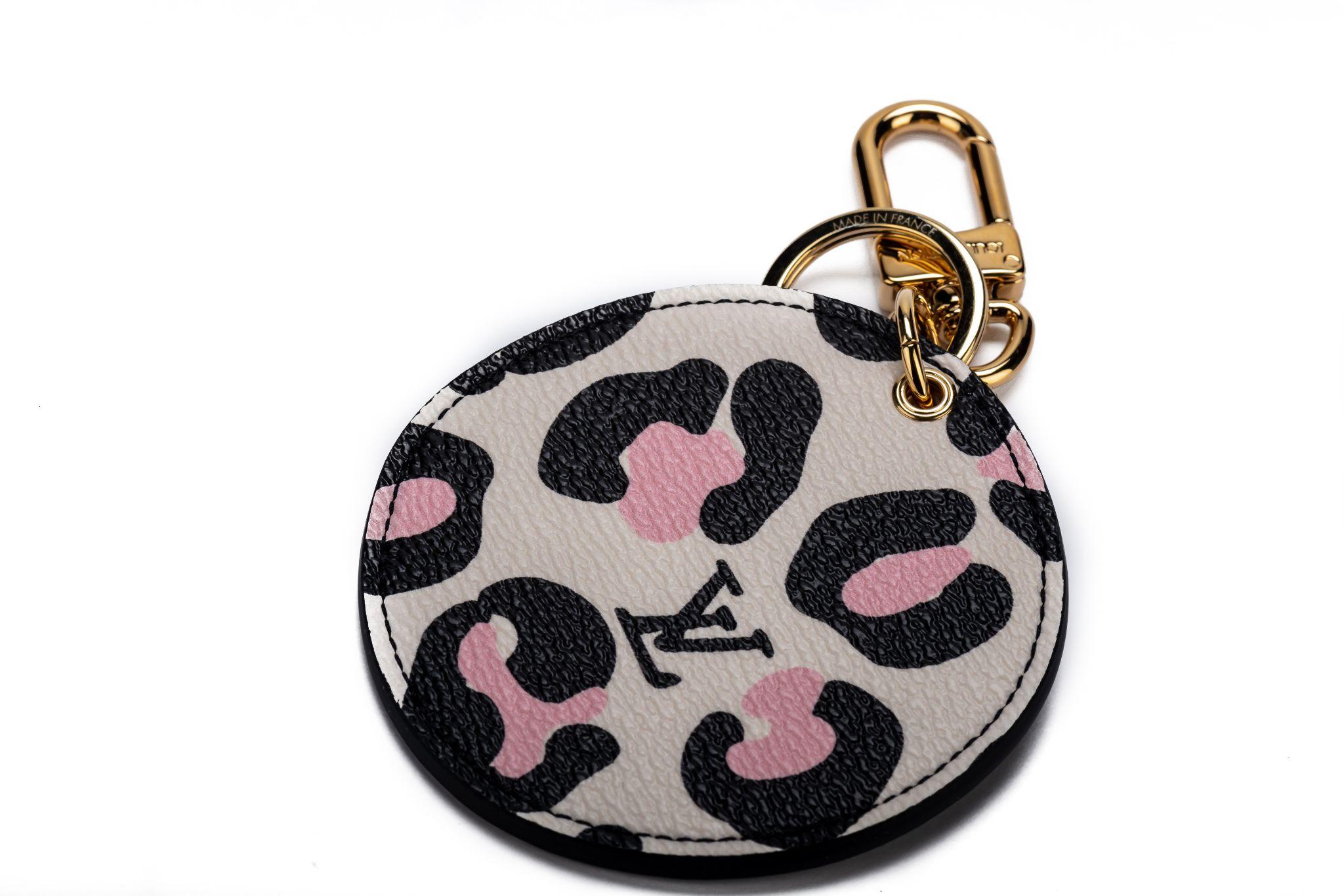 This Wild at Heart Illustre bag charm and key holder has a free-spirited feel with the irregular round shape of its hanging canvas medallion. This medallion is brightly decorated with a Monogram Flower on one side and leopard spots and the LV