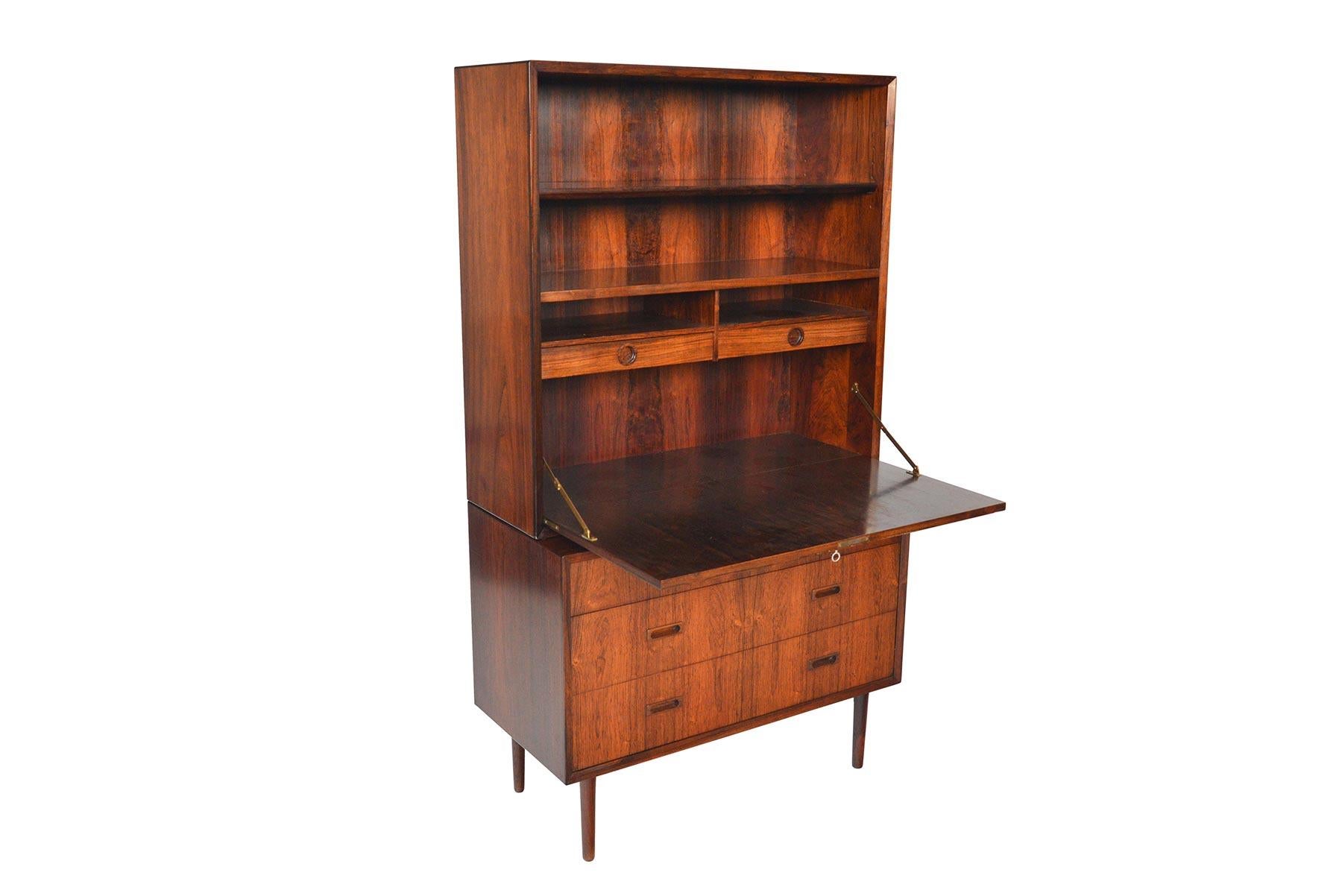 This versatile storage piece was manufactured by Lyby in the 1960s. Beautifully crafted the base of this piece is a four drawer gentleman’s chest. A removable hutch with a drop down secretary desk sits atop. The locking door opens to reveal two