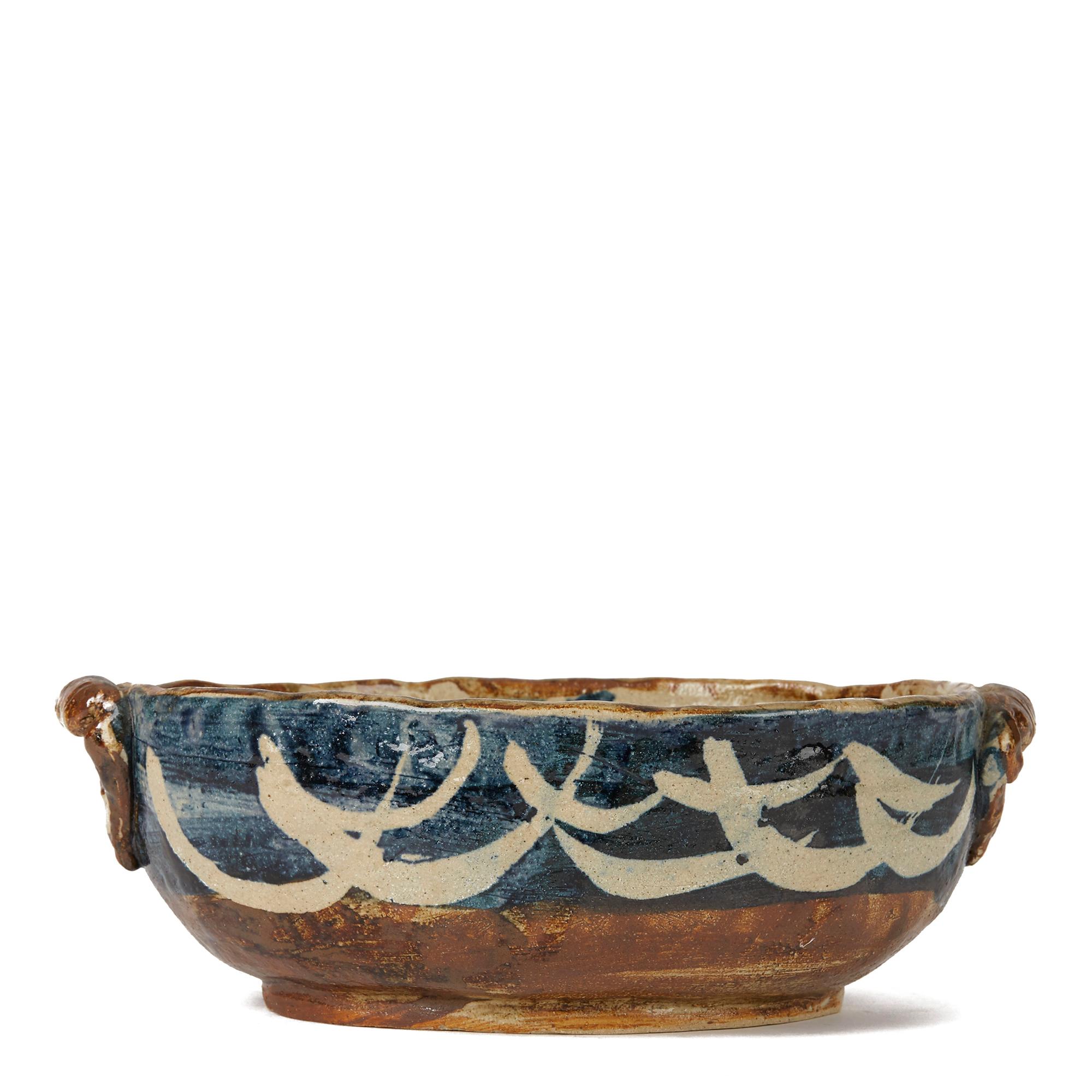 A rare studio art pottery bowl of oval shape applied with lug handles to either end by Lydia Corbett (Sylvette David). The heavily potted bowl is hand painted in tones of brown and blue on a natural glazed ground and is not marked.

Sylvette David