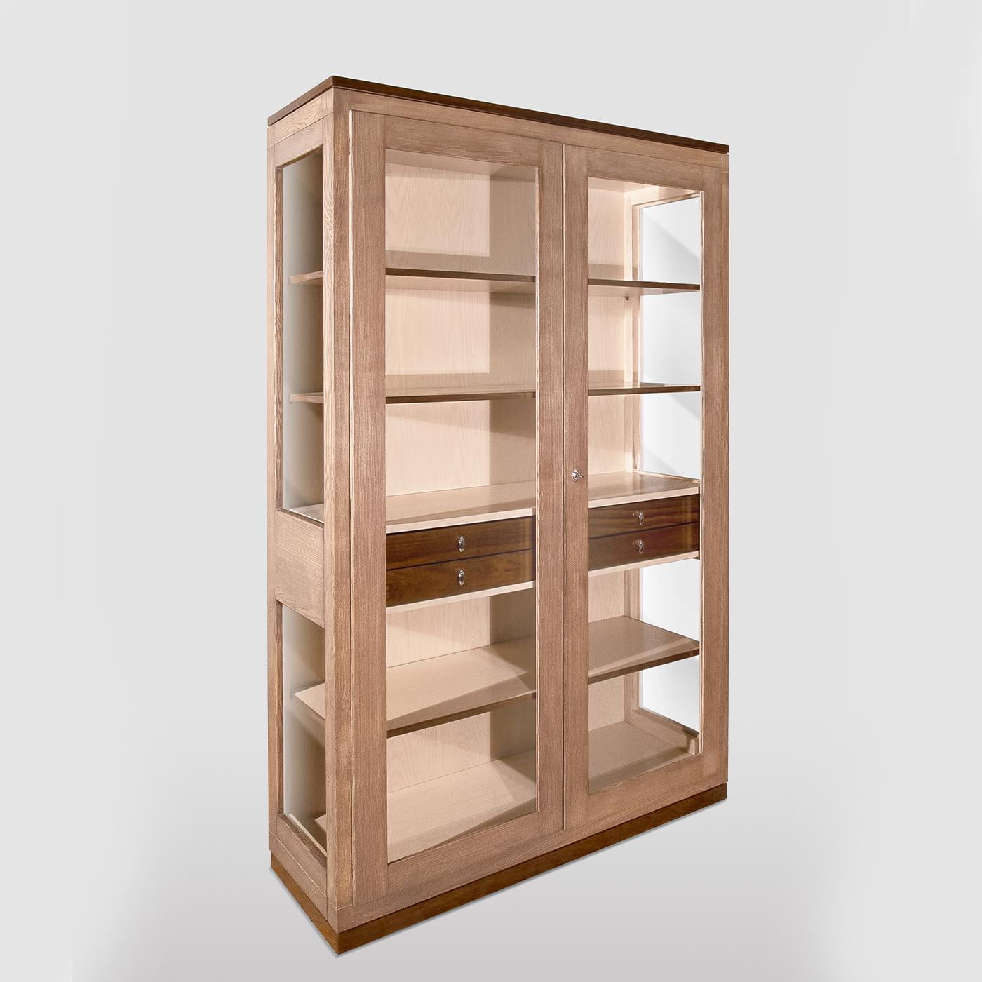 This modern display cabinet, characterized by simple and linear design, is a stylish storage option for the most precious collections. It features a tall structure handcrafted of ash and solid walnut wood supported by a plinth base with leveling