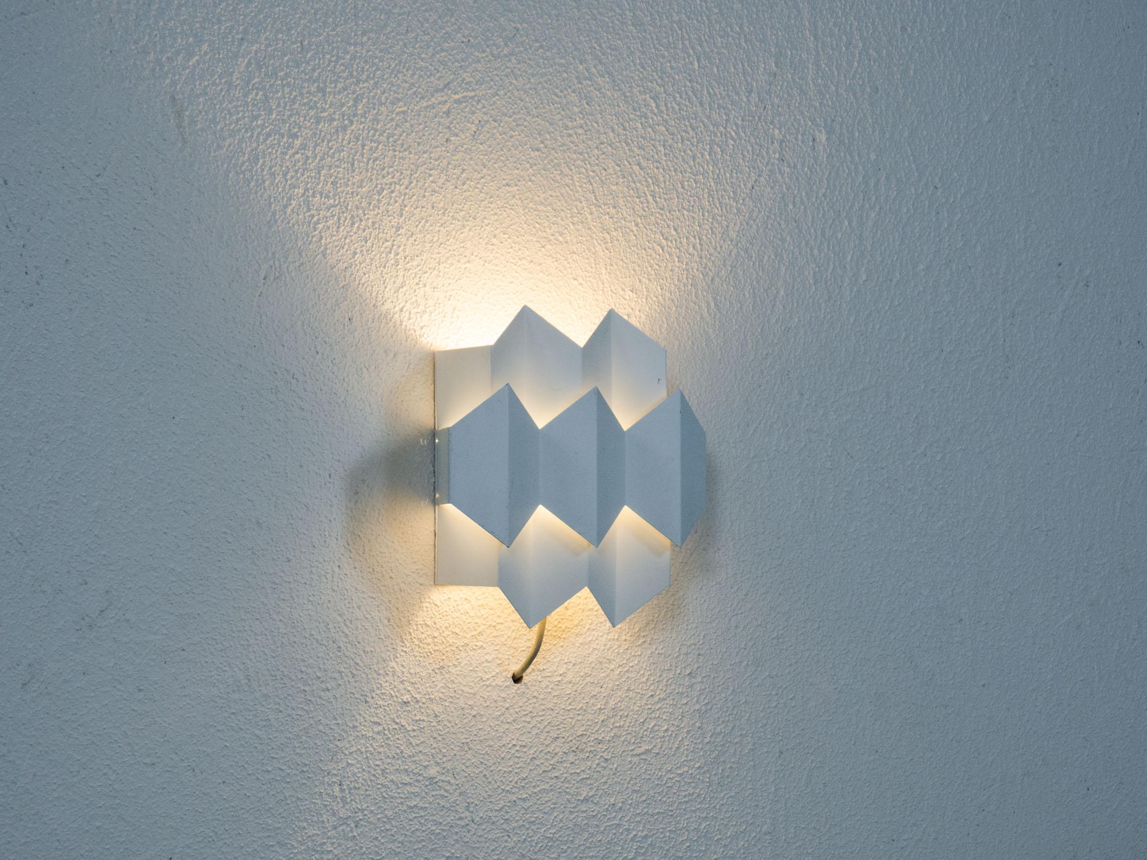 Wall lamp manufactured by Danish lighting company Lyfa, a household name, and designed by Bent Karlby.

This modestly sized fixture is made from plated steel and is lacquered white. Septet, the name of this model comes from the seven hexagons the