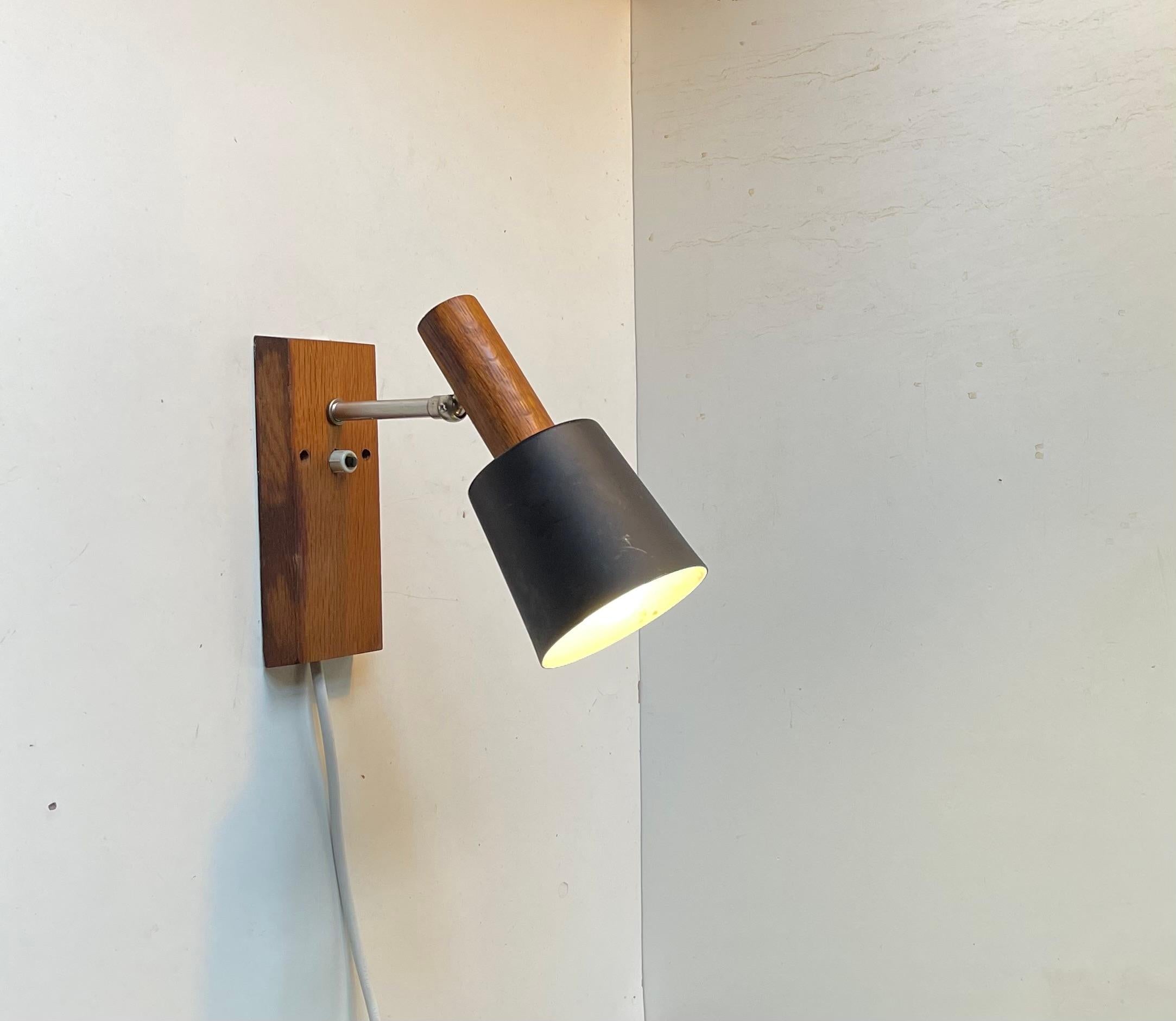 Lampada da parete composta da acciaio, teak massiccio e un paralume in alluminio nero ardesia. Prodotto da Lyfa in Danimarca negli anni '60. Si chiama 