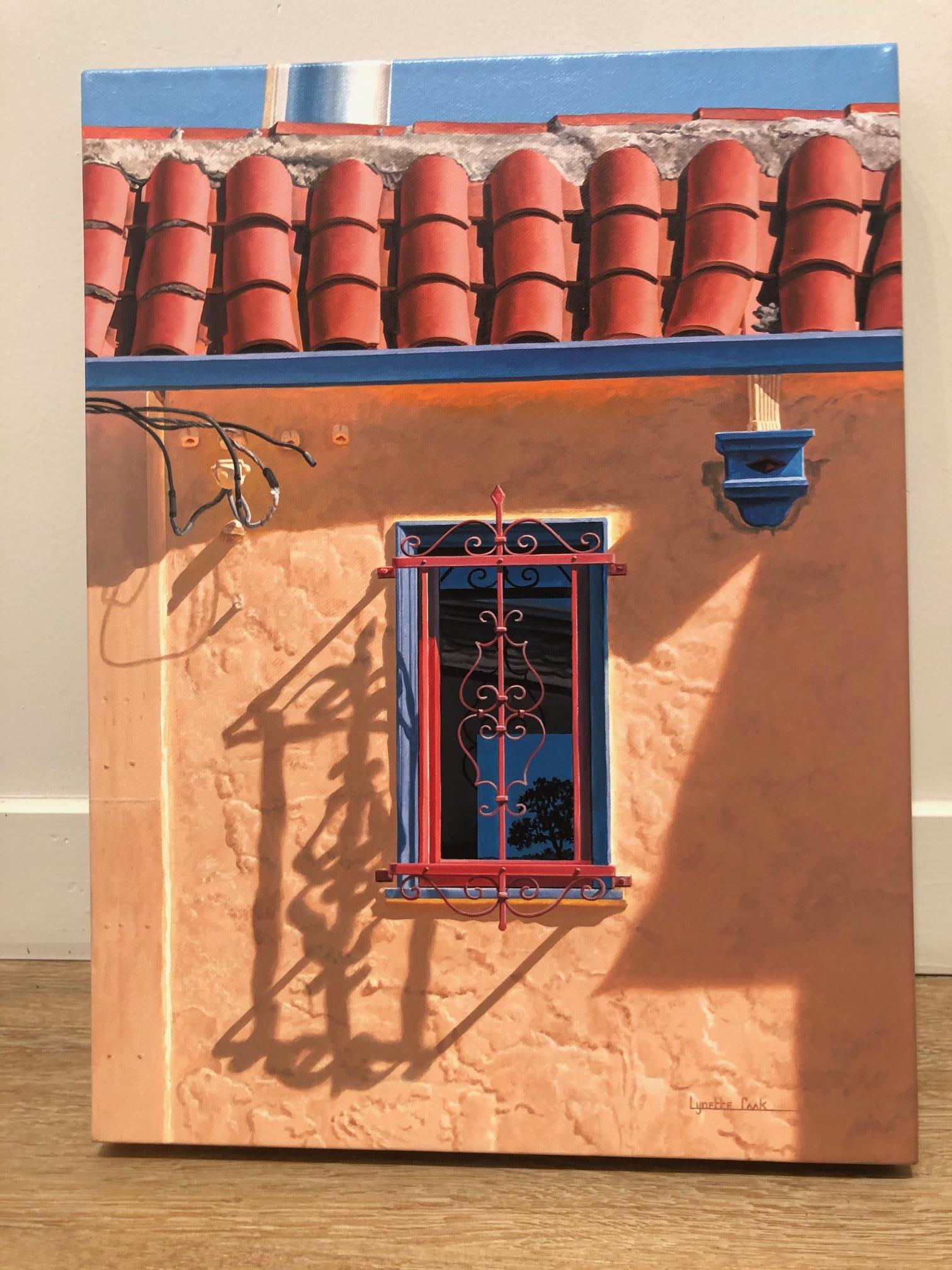 'Edge: McAllister Charm' depicts the sun lit facade of a building with terra-cotta roof tiles and a tree reflected in a blue window.   The work of art is meticulously hand painted by Lynette Cook, who realistically depicts scenes that she sees