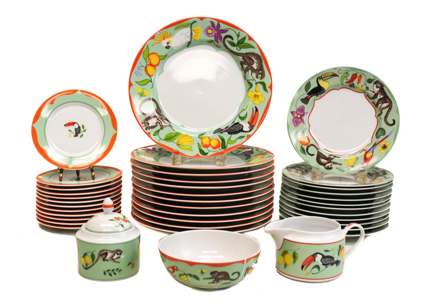Lynn Chase fine China porcelain dinner service for 12 Monkey Business, 1995. Charming pistachio green and orange grounds to the dishes with various monkeys, birds, and fruits throughout. Lynn Chase marks to the verso. 

The service includes: 
-