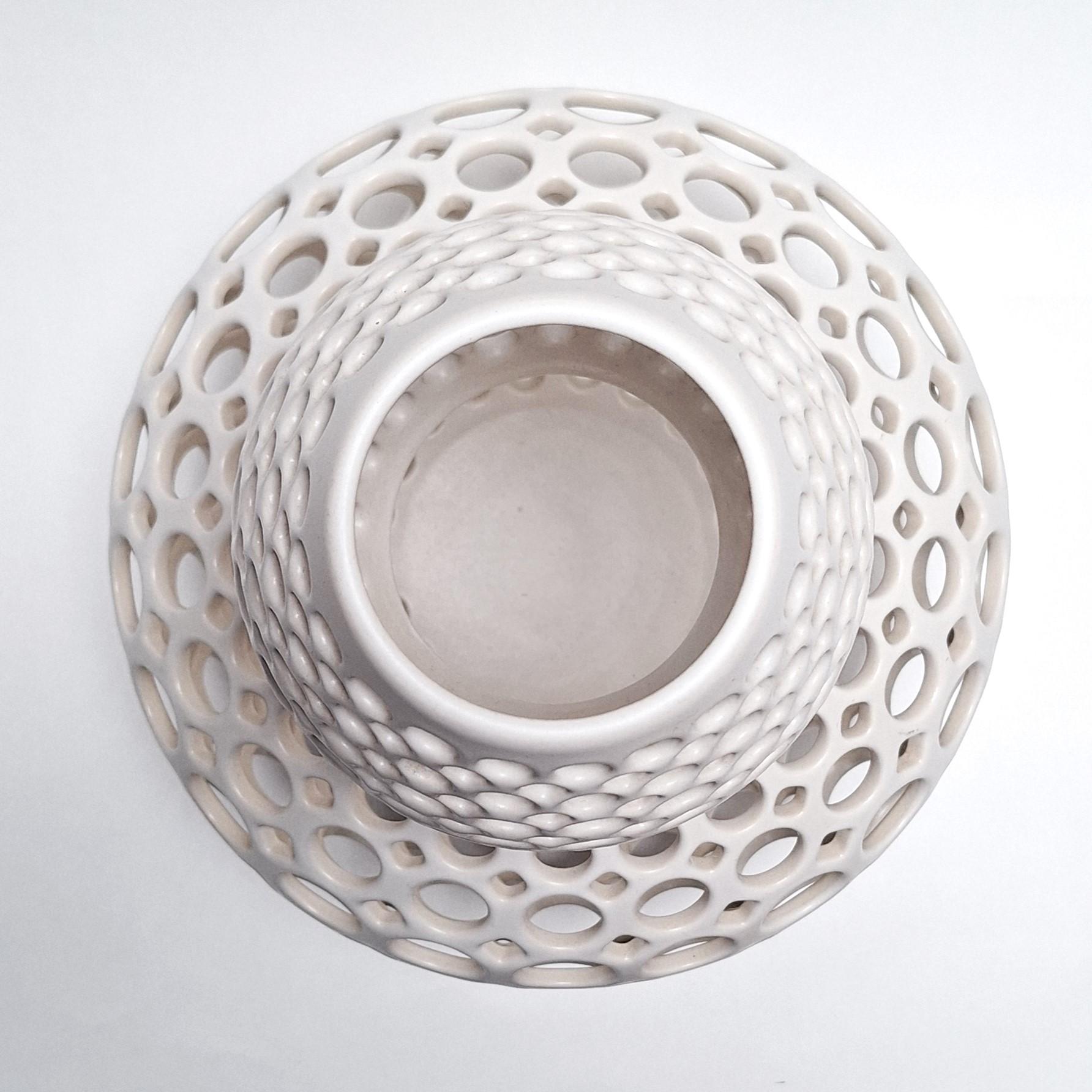 This Double Gourd Round Lace White Vessel is a unique medium size contemporary modern ceramic object by Californian artist Lynne Meade. It is wheel thrown, hand pierced and has a smooth white satin glaze. Everything is done by eye, without molds or
