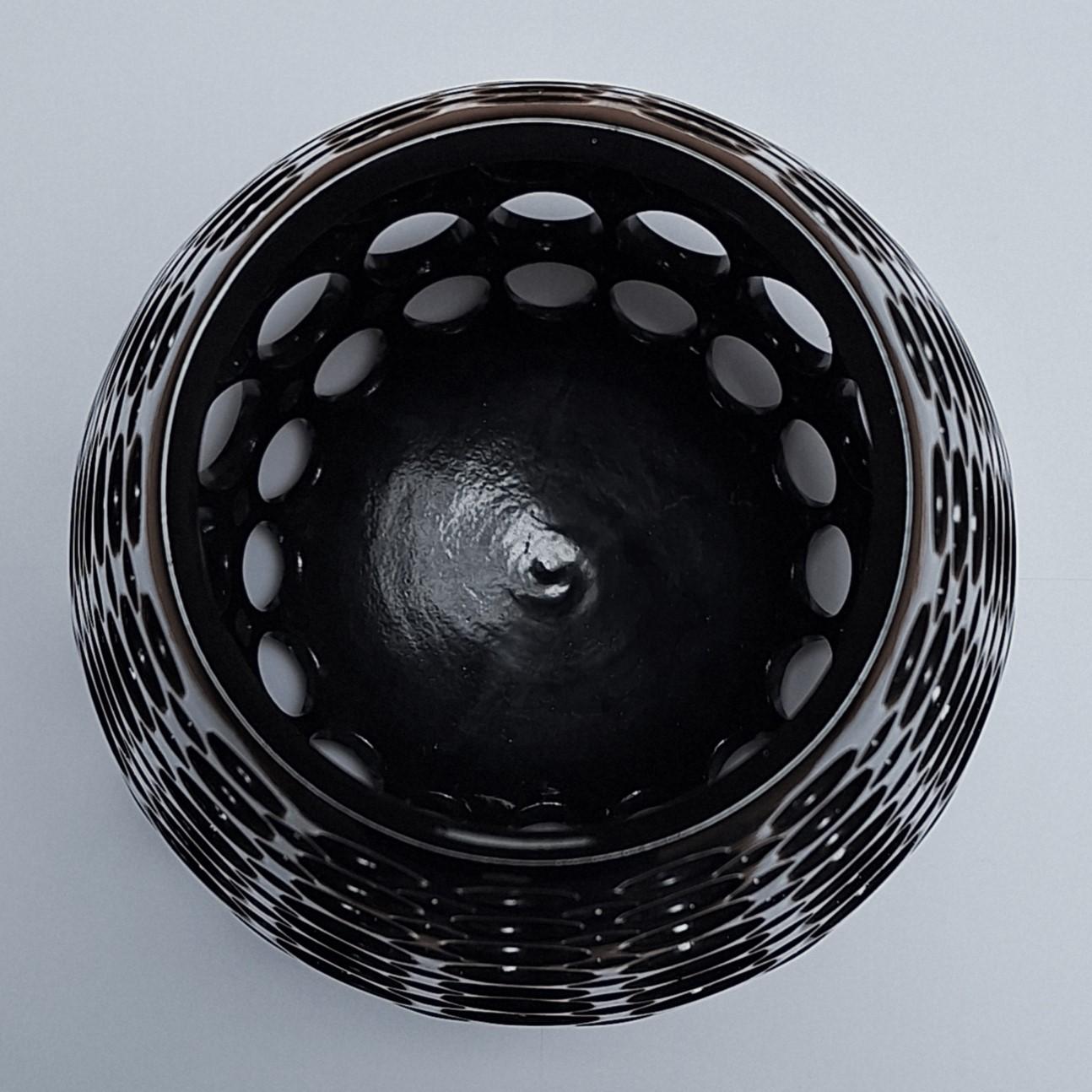 This Elongated Teardrop Round Lace Black Vessel is a unique medium size contemporary modern ceramic object by Californian artist Lynne Meade. It is wheel thrown, hand pierced and has a smooth black gloss glaze. Everything is done by eye, without