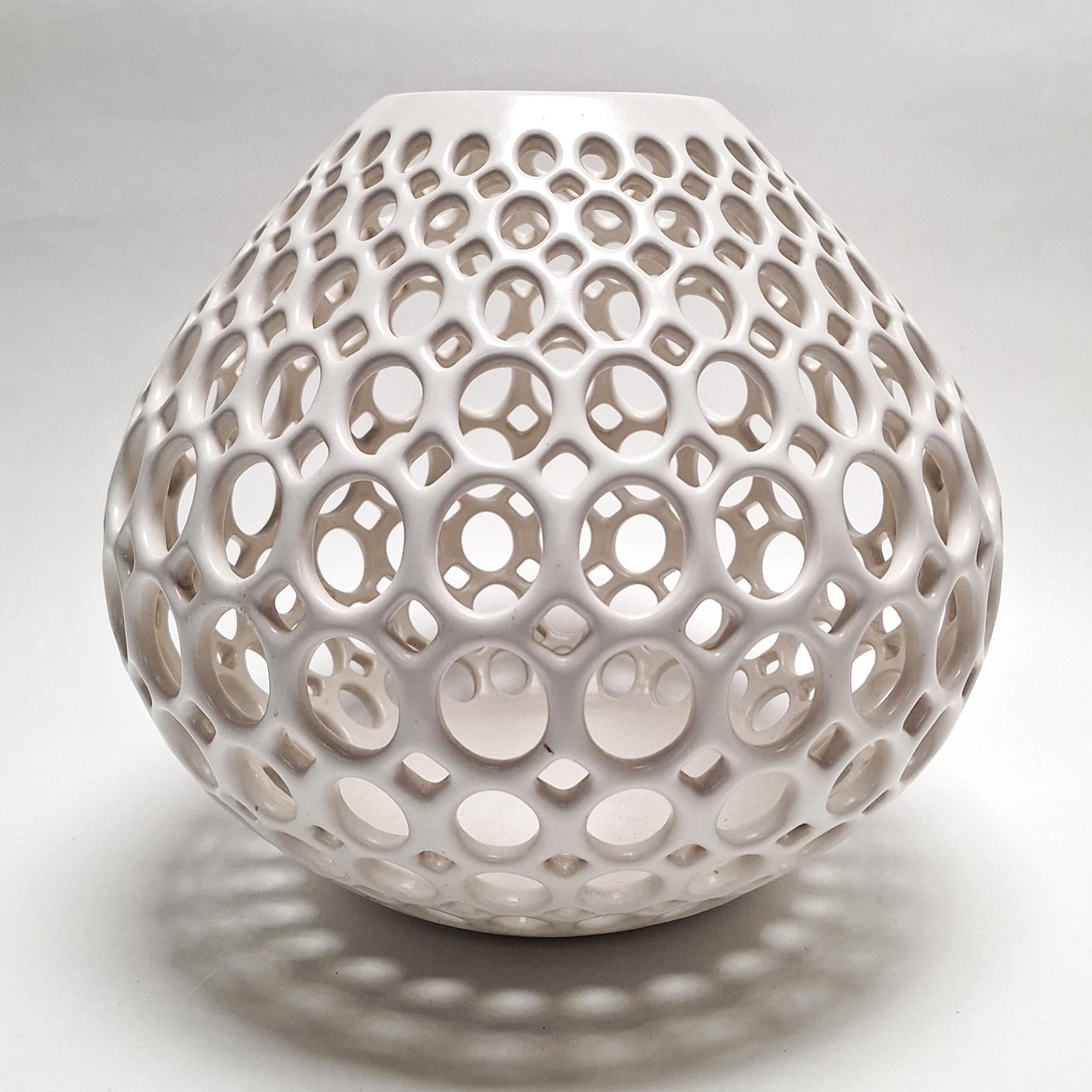 This Teardrop Oval Lace White Vessel is a unique medium size contemporary modern ceramic object by Californian artist Lynne Meade. It is wheel thrown, hand pierced and has a smooth white satin glaze. Everything is done by eye, without molds or