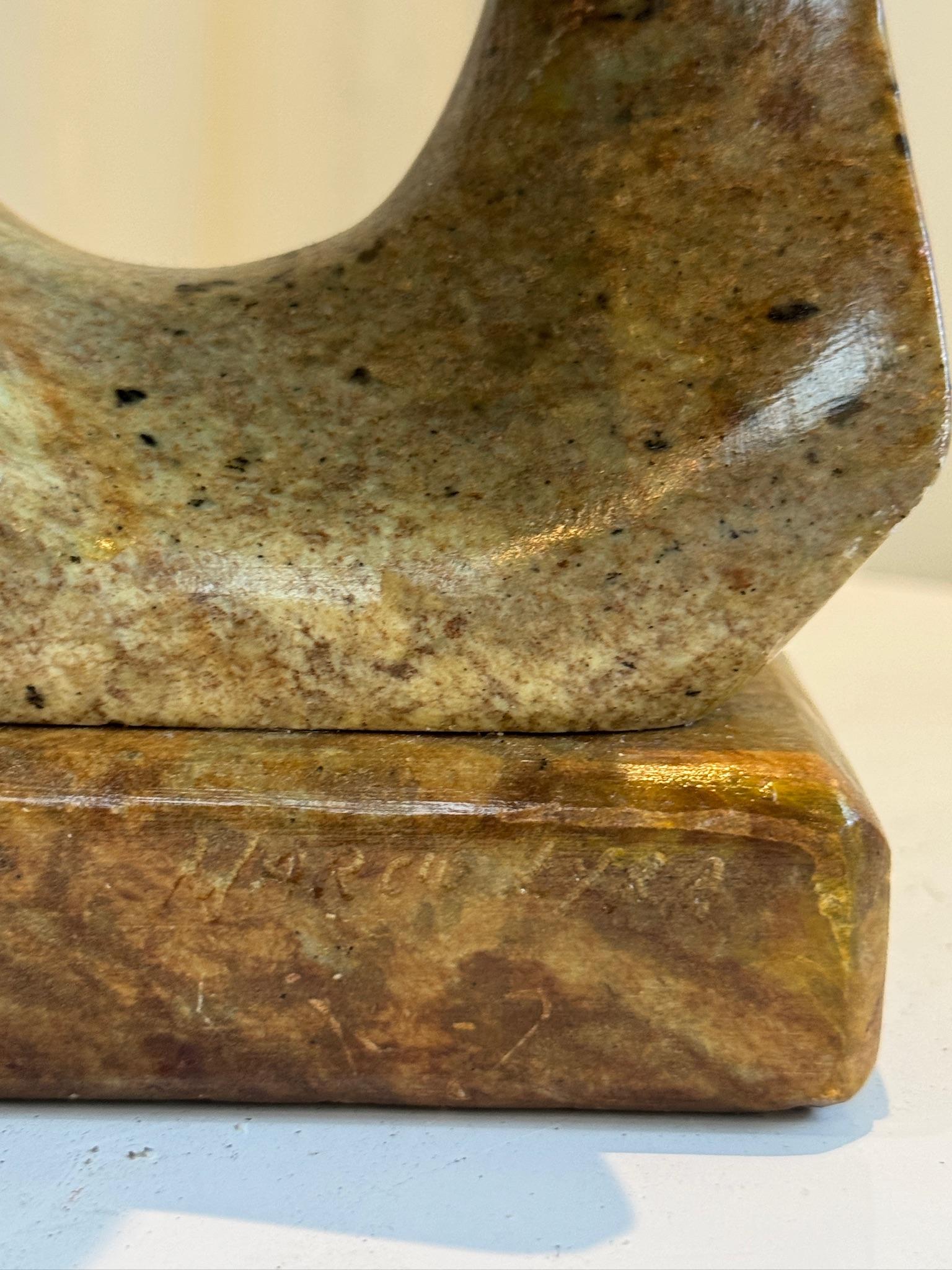This is a striking Mid-Century Modern (MCM) soapstone sculpture titled Lyra. The abstract form depicts a flowing human figure, skillfully carved from richly colored soapstone with natural veining. The piece is signed by the artist, adding to its