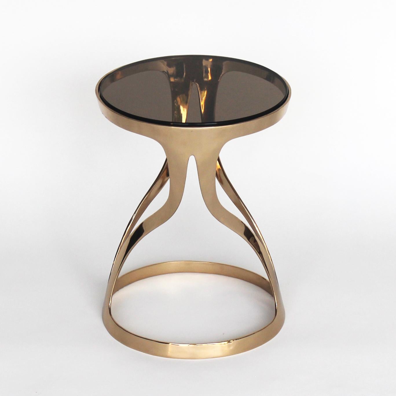 An elegant and sophisticated profile define the Lyra table with an infinite bi-directional flowing movement. Cast in bronze and hand polished with a smoked tinted glass top.

Hand forged and cast bronze pieces bare the marks of artisanal creation