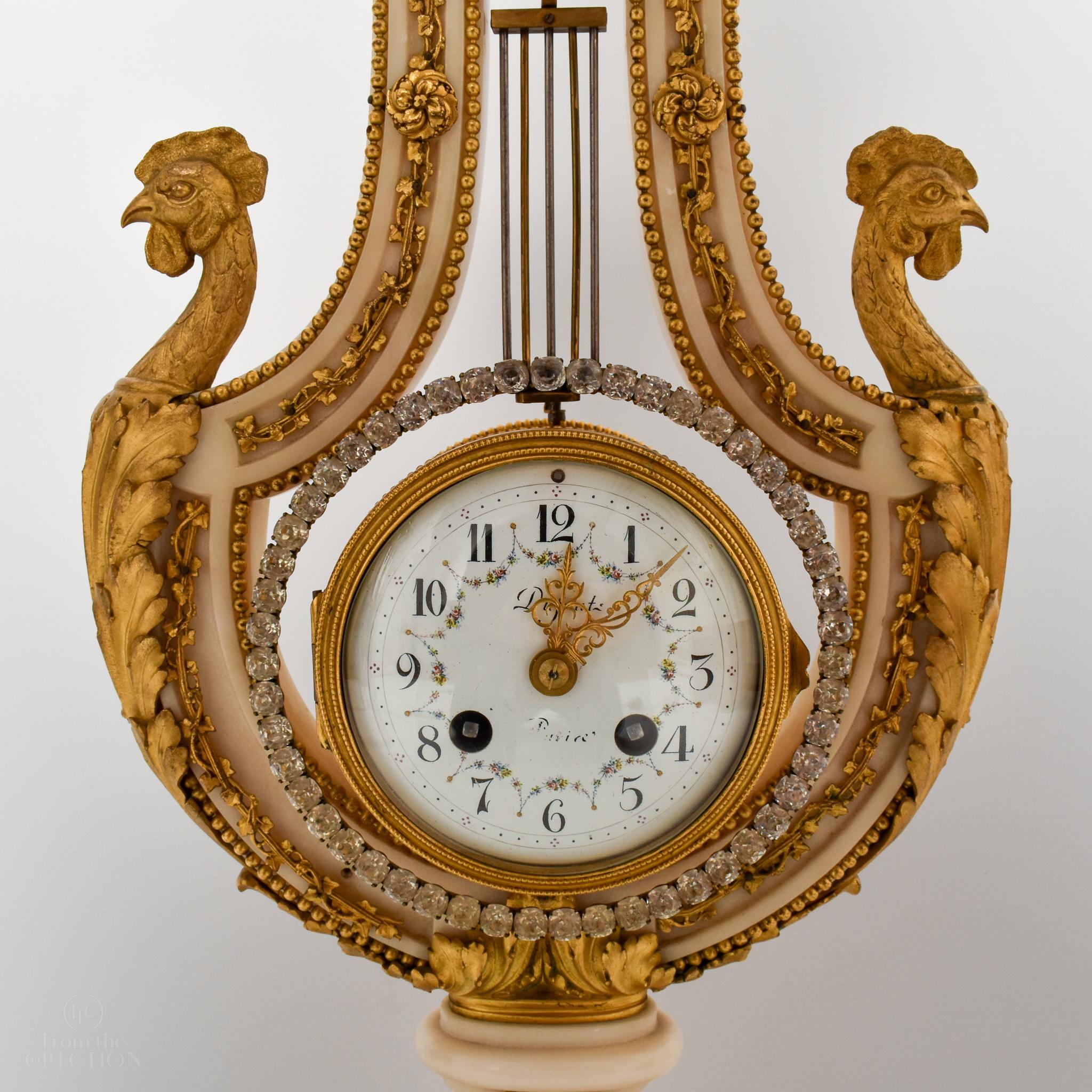 19th Century clock in the shape of a Lyre with a sun at the top. It is a beautiful clock that will add class and elegance to any mantle piece. The sides of the clock have a pair of cockerels.