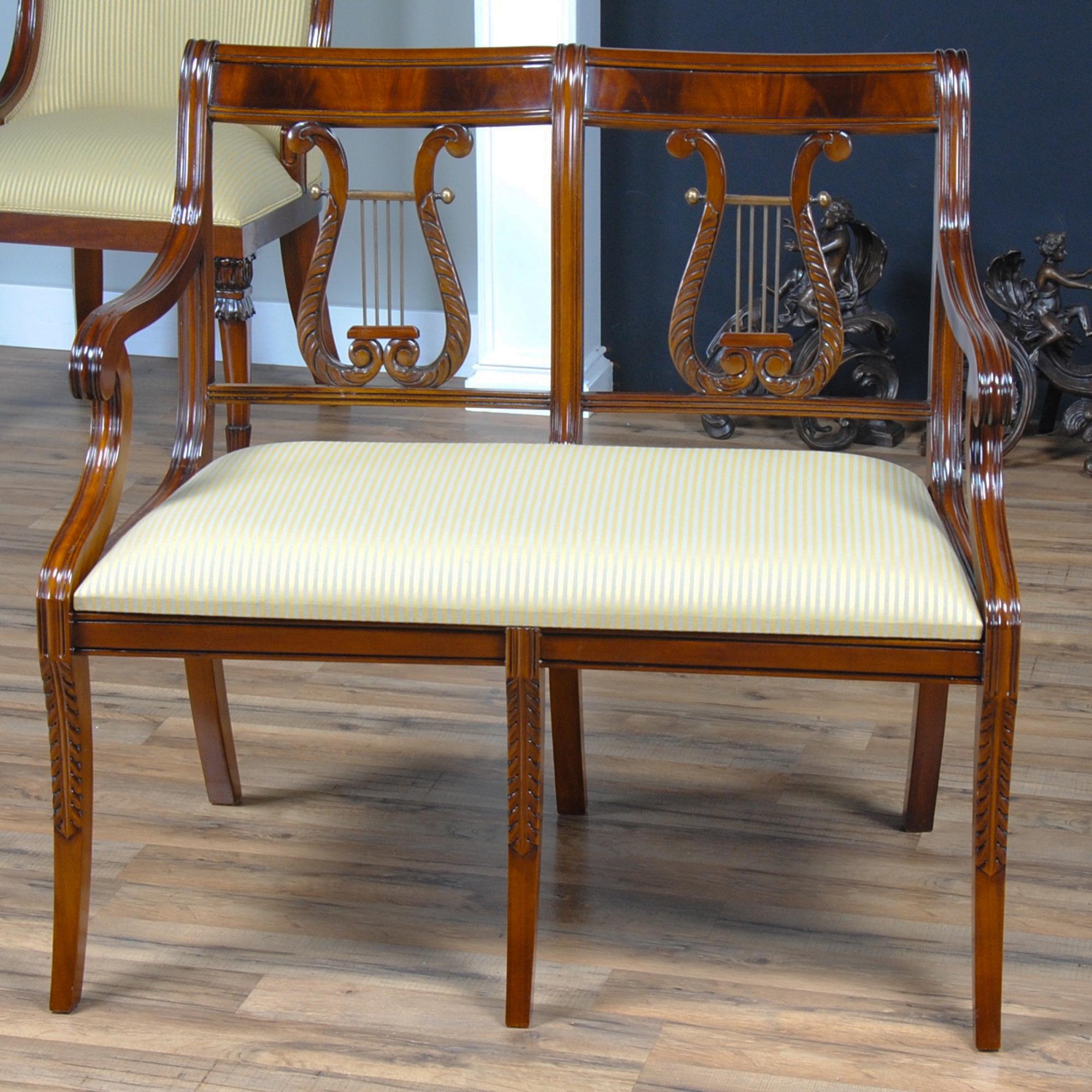 This high quality, hand carved Lyre Two Seat Chair features a figural mahogany crest rail, lyre carved back splat with brass decorations, and legs featuring acanthus carvings ending in tapered and shaped saber feet. Beautifully finished with our