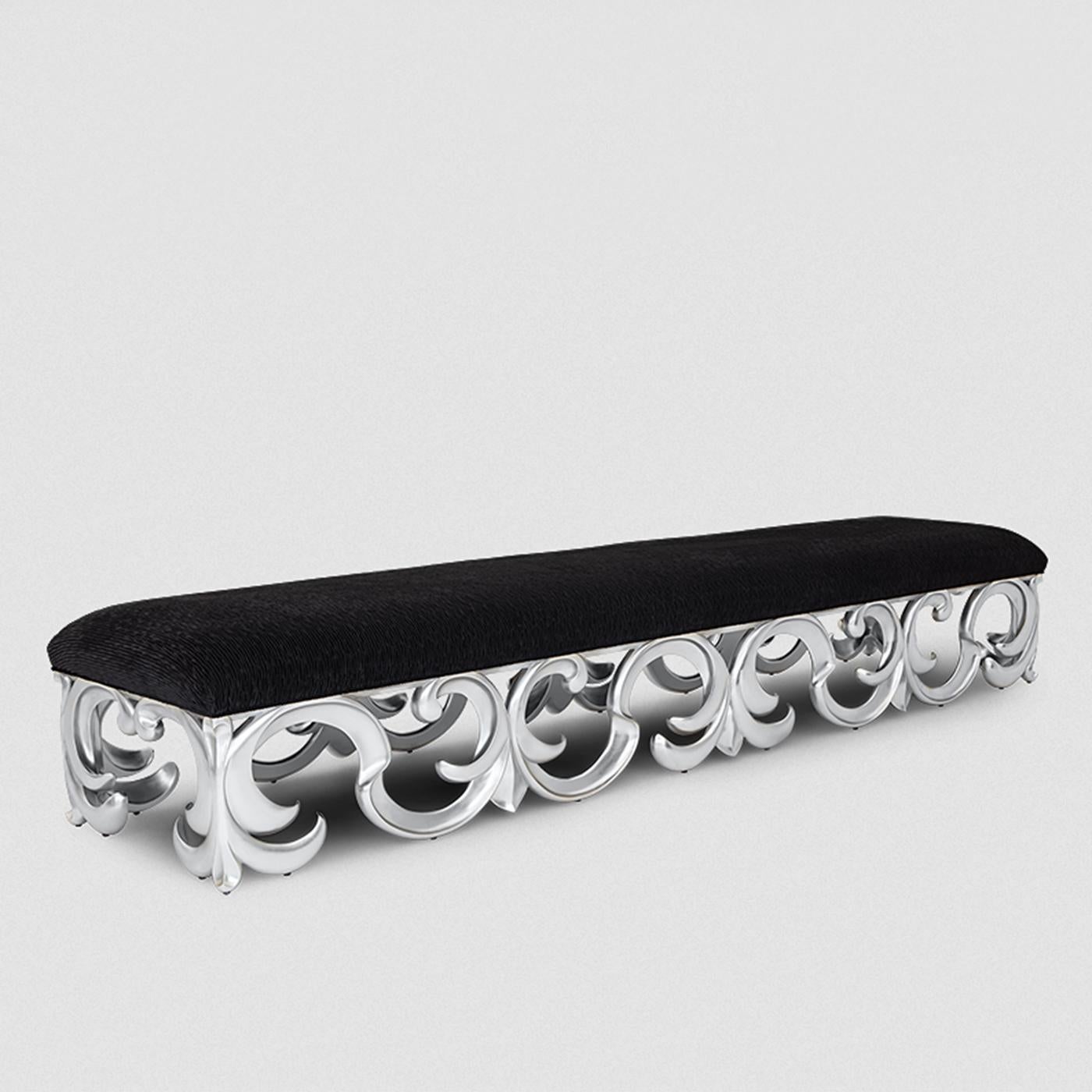 Bench Lys with all structure in solid hand-carved
mahogany wood in silver leaf finish. Seat upholstered
and covered with high quality black fabric with trims.
Also available with other wood finishes on request and
with other fabrics, on request.