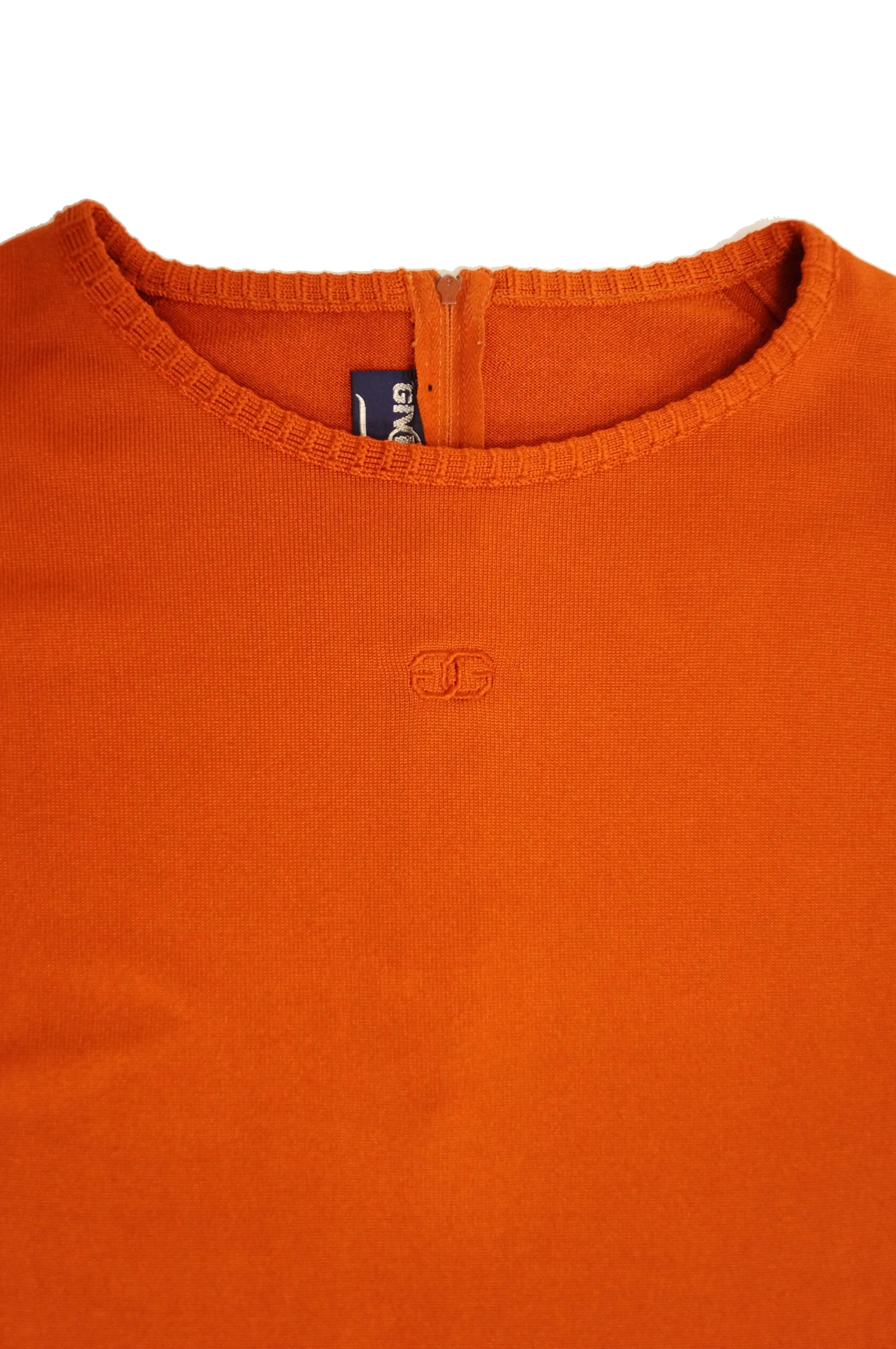 Fabulous bright orange knit sweater by Hubert de Givenchy! The sweater has long sleeves, a loose jewel neck collar, and hits slightly above the hip. The famous Givenchy logo is featured on the front of the sweater, at the center of the collarbones -