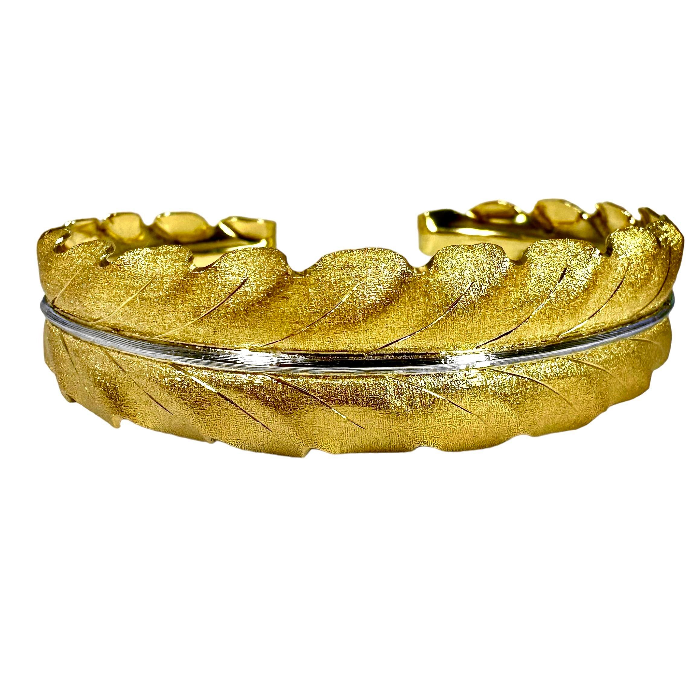 This classic Mario Buccellati Laurel Leaf bangle bracelet is deftly crafted in his characteristic, textured 18k yellow gold surface, and with an 18k white gold center vein. This model is a perennial item in Buccellati's line. It is made to fit a