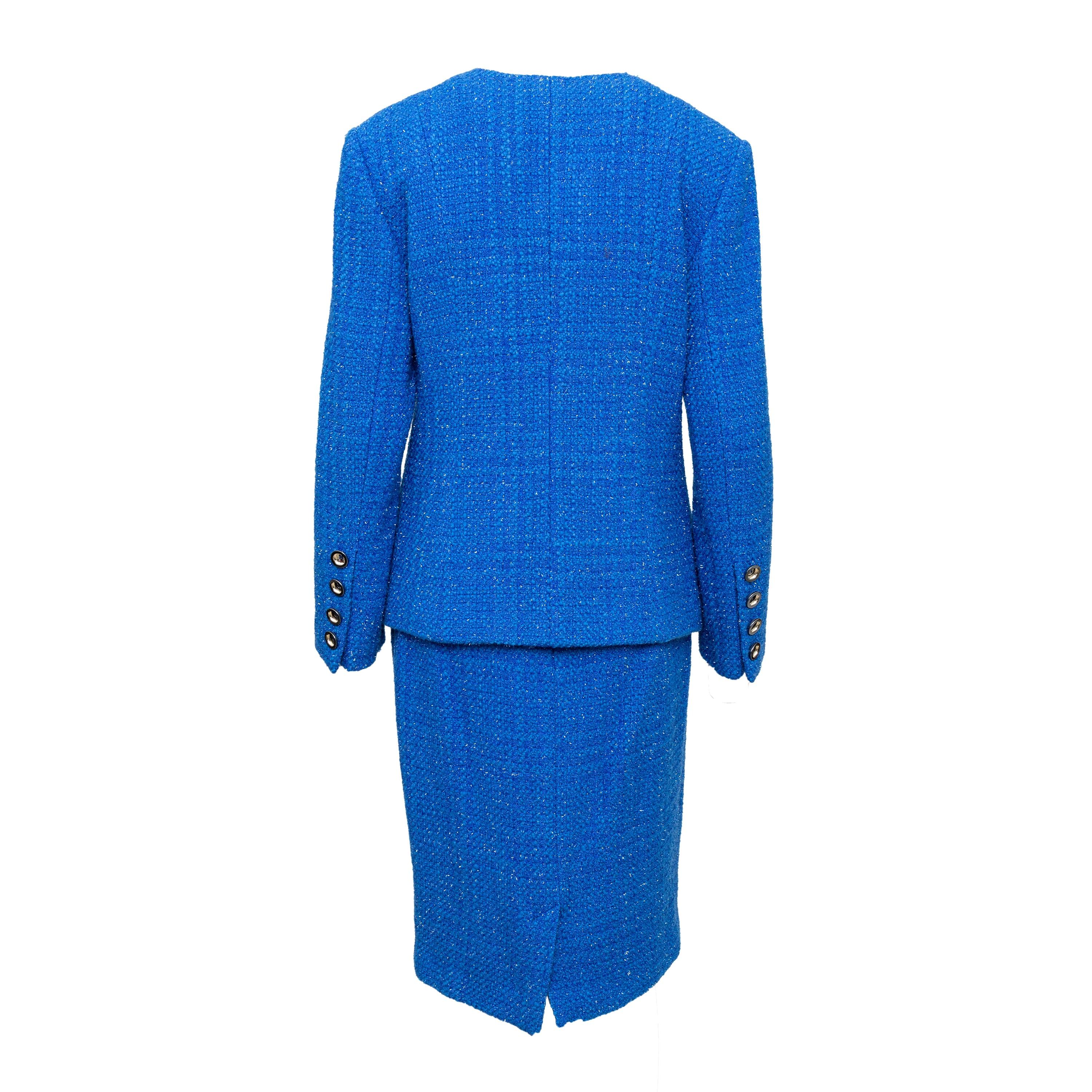 Questo set in lana di M. Claudette è composto da una giacca in tweed blu brillante e da una gonna midi in misto lana. Scollo a V con bottoni argentati, tasche con patta e cerniera di ventilazione posteriore.
 Osservazioni: Ci sono piccoli fori nella