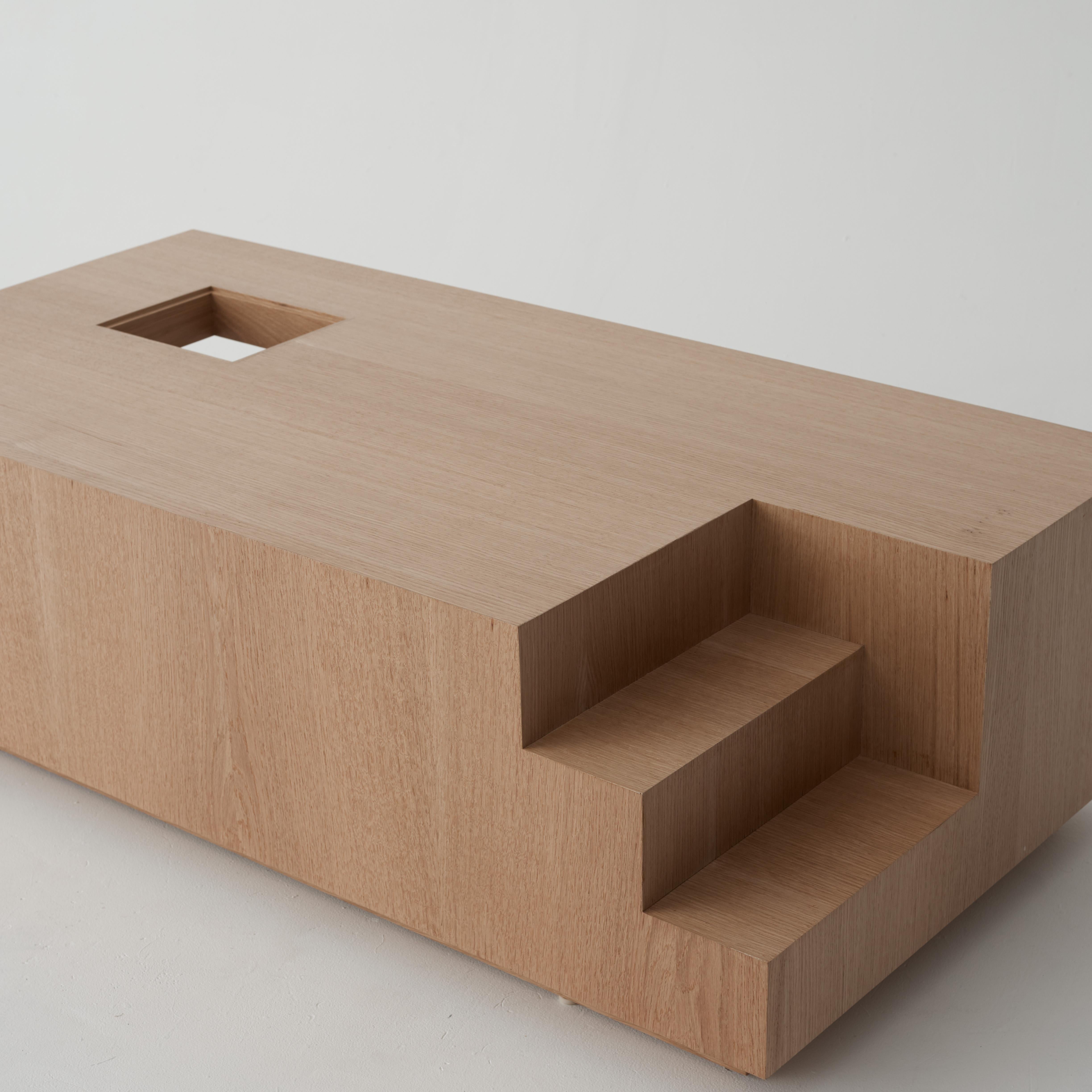 L'homme modulaire de Le Corbusier et le nombre d'or définissent les proportions de la table M-Coffee. Cette table est une étude d'échelle ; conçue comme une simple masse rectangulaire creusée aux points clés pour produire des détails architecturaux.