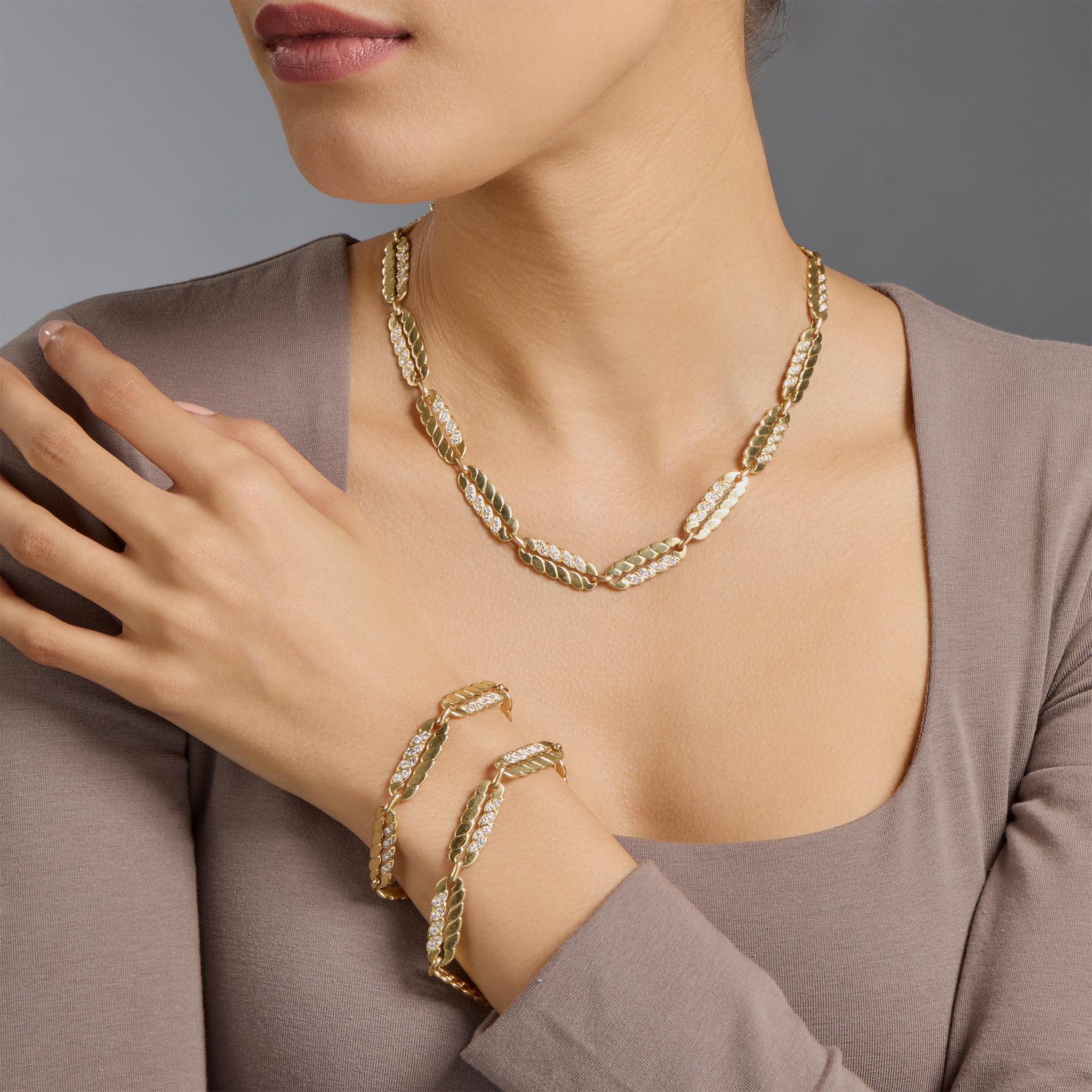 Dating from the 1970s, this transformable 18K gold and diamond chain is by M. Gérard, Paris. The longchain is composed of elongated oval scalloped links highlighted by round brilliant-cut diamonds, and is convertible into a shorter necklace and two