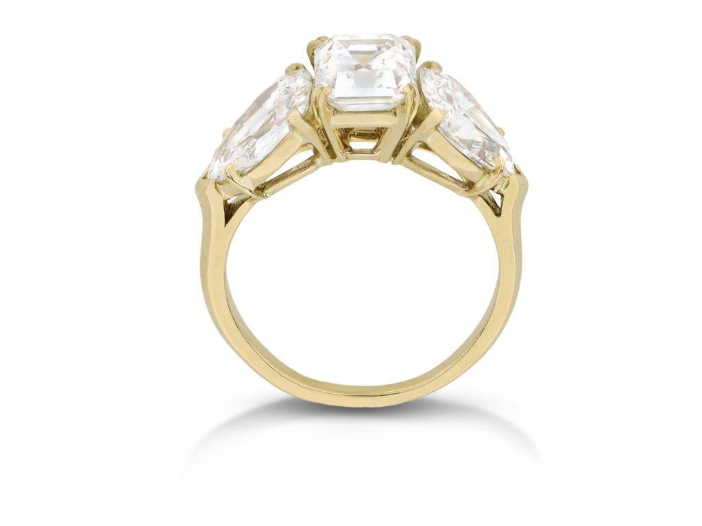 M. Gérard diamond three stone ring. Set to centre with a rectangular step-cut diamond, G colour, VS2 clarity with a weight of 1.87 carats in an open back claw setting, flanked by two drop shape transitional cut diamonds in open back claw settings