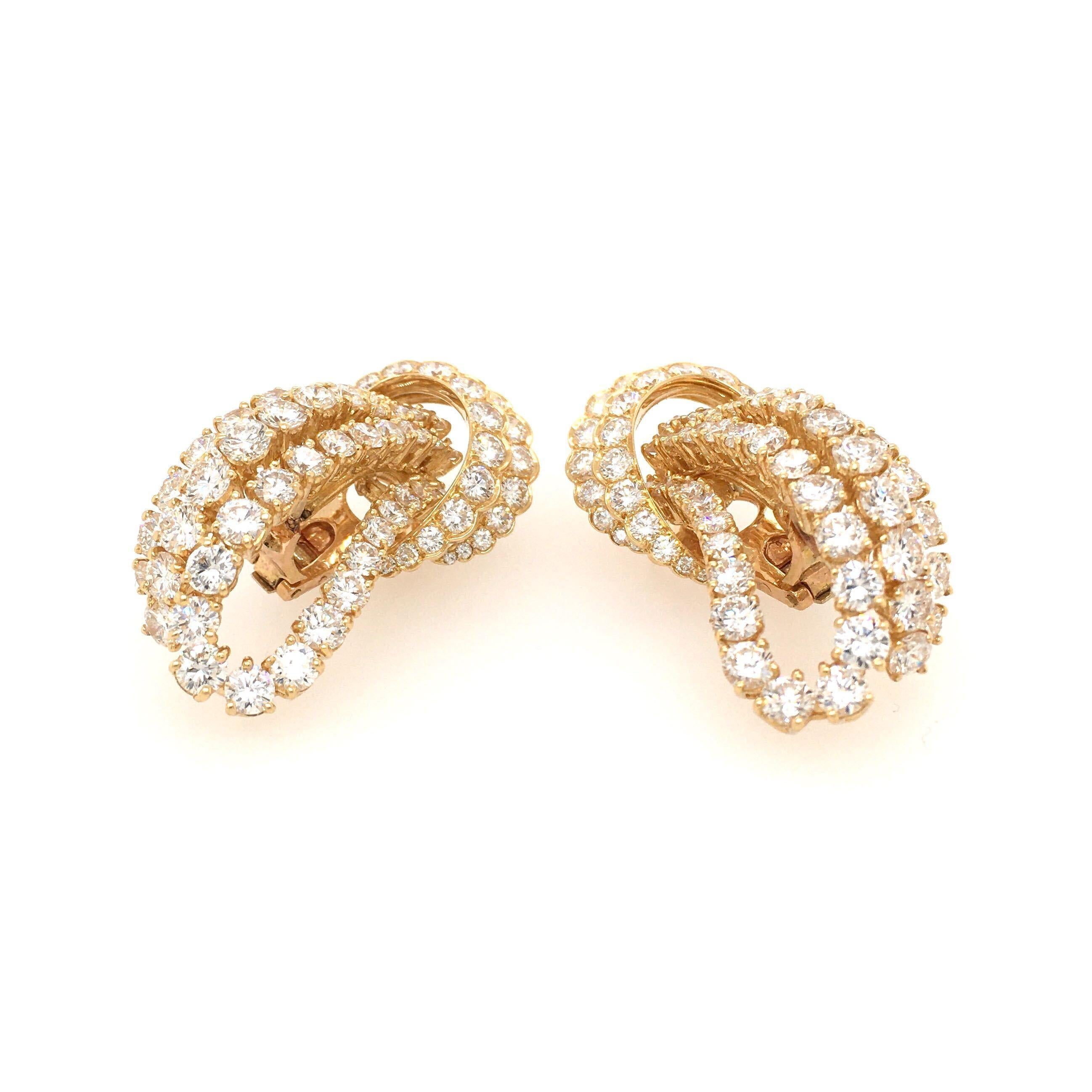 A pair of 18 karat yellow gold and diamond earrings. M. Gerard. Designed as a scrolling diamond loop. One hundred and forty  diamonds weigh approximately 15.00 carats. Length is approximately 1 3/4 inches, gross weight is approximately 30.1 grams.