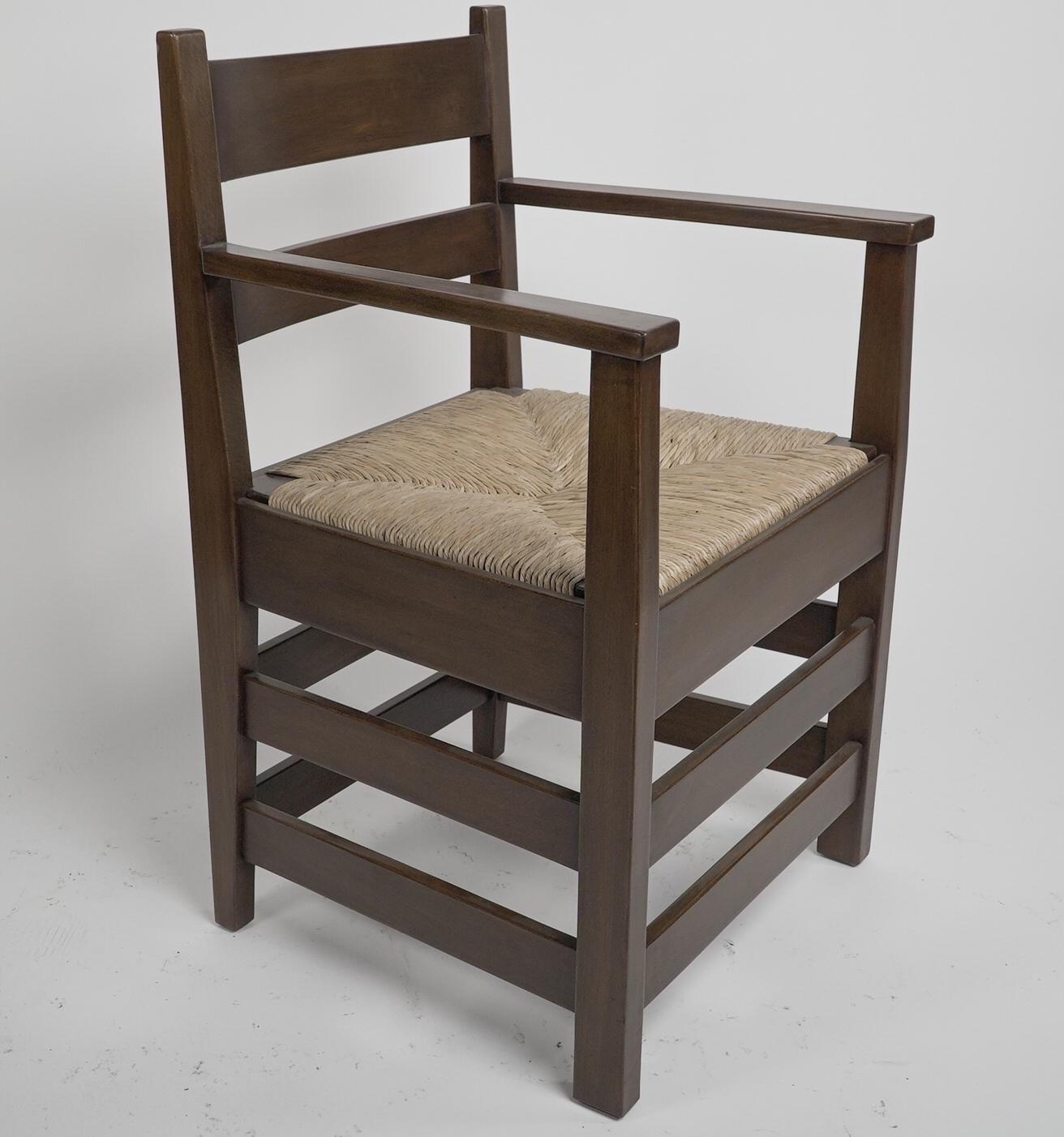 M H Baillie Scott von J P White. Ein Sessel aus Nussbaum im Arts & Crafts-Stil mit einem neuen Sitz aus Binsen. Abgebildet in: Möbel aus den Pyghtle Works in Bedford, von J. P. White. Möbel entworfen von M H Baillie Scott.
