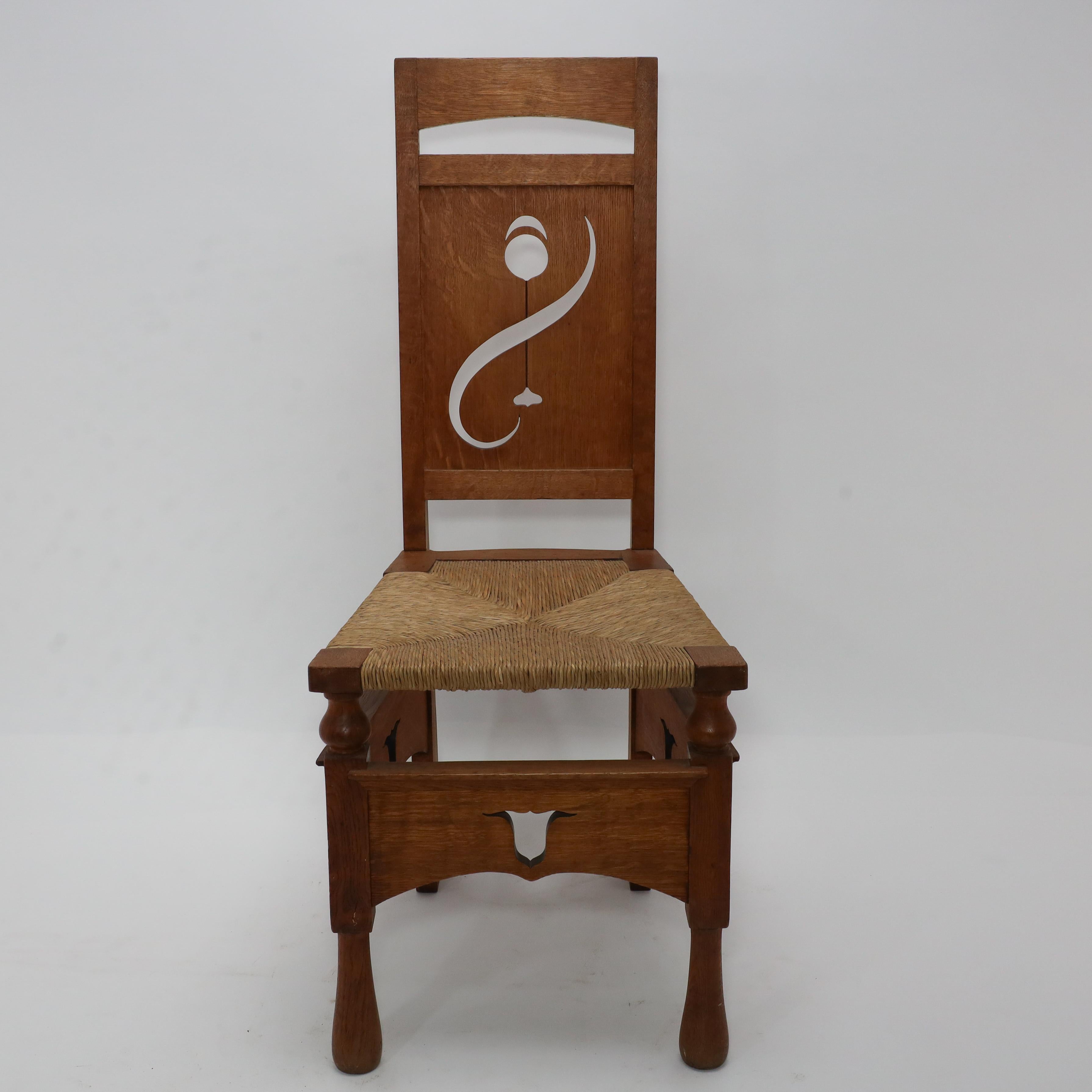 M H Baillie Scott attri, An Arts & Crafts Oak Chair With Stylised Floral Cut-Outs to the back and Pierced Tulips to the aprons below the front and the sides of the seat.
A very progressive chair in its style and form with turned details below the
