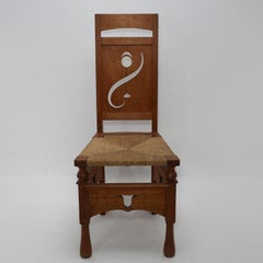 M H Baillie Scott attri An Arts & Crafts Oak Chair With Stylised Floral Cut-Outs